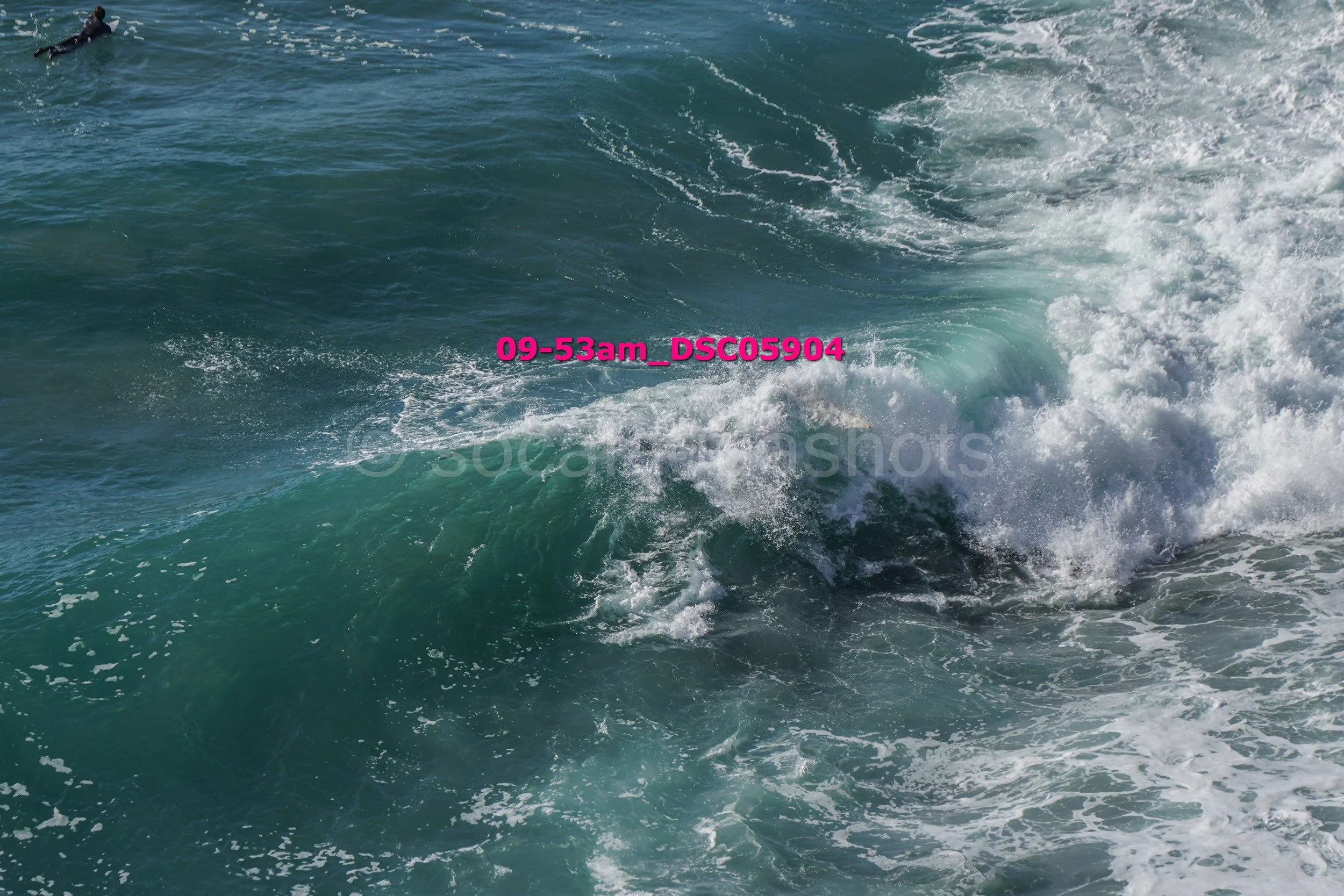 Ocean waves crashing with a swimmer in the water, timestamp 09-53am, image file DSC05904.