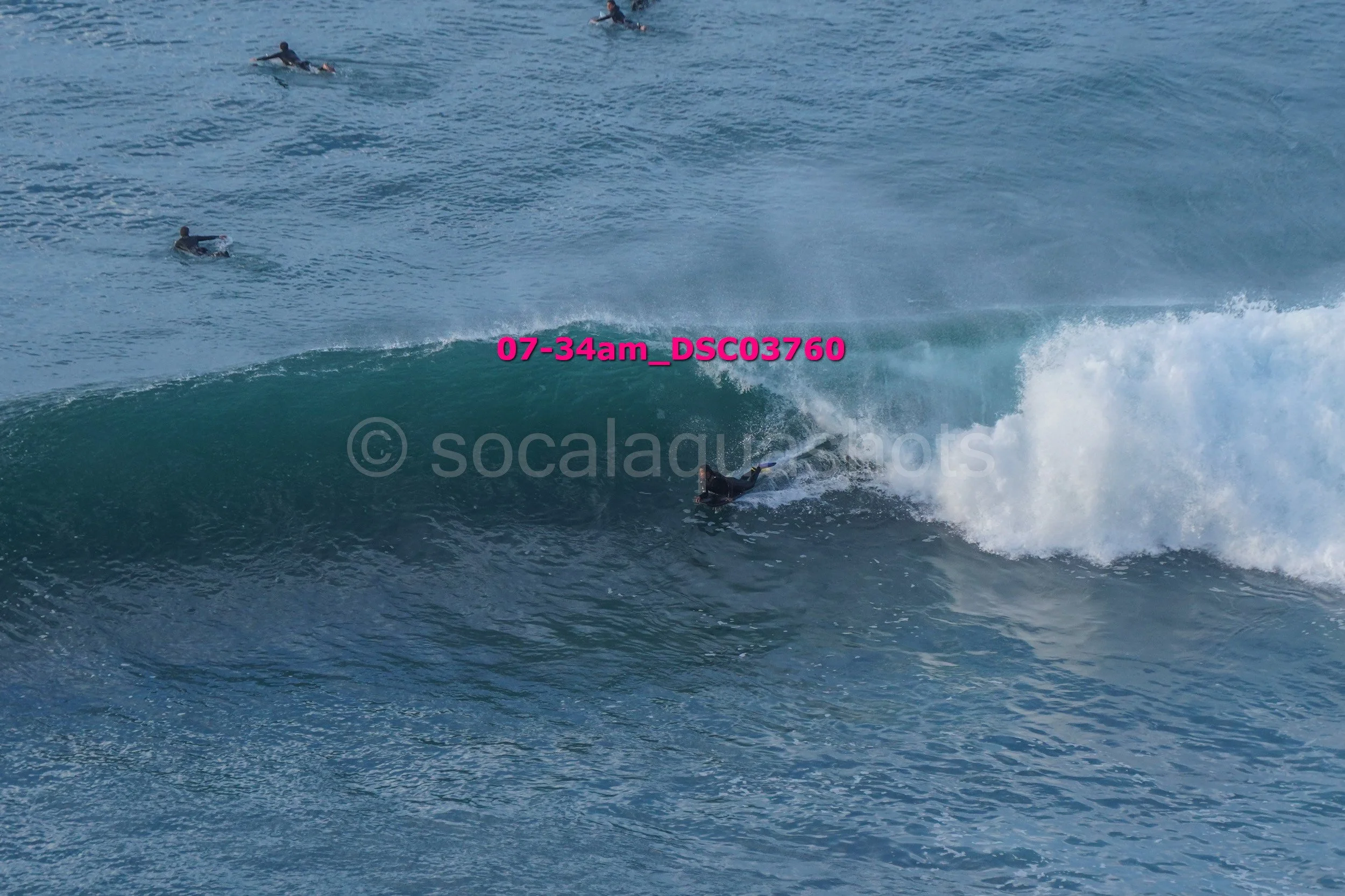 Surfer riding a wave with several surfers in the water nearby