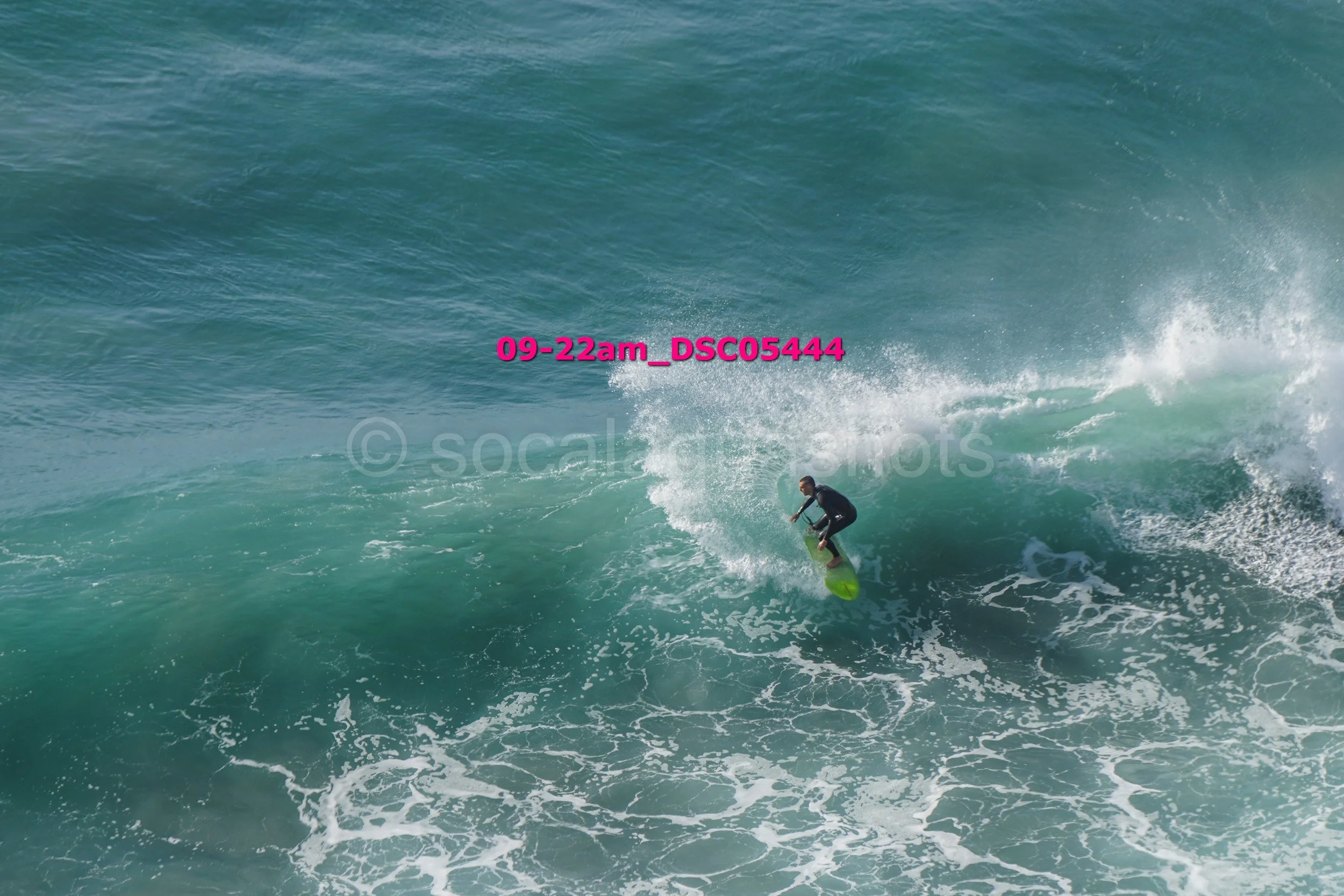 A person surfing on a large wave in the ocean.
