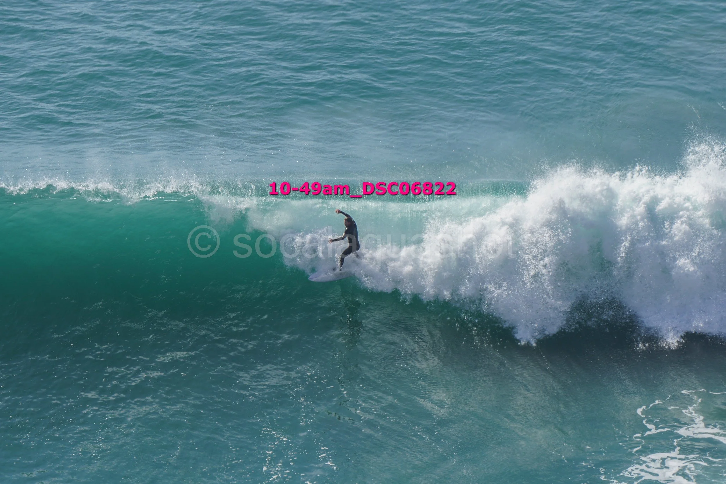 A person surfing on a wave in the ocean during daytime.