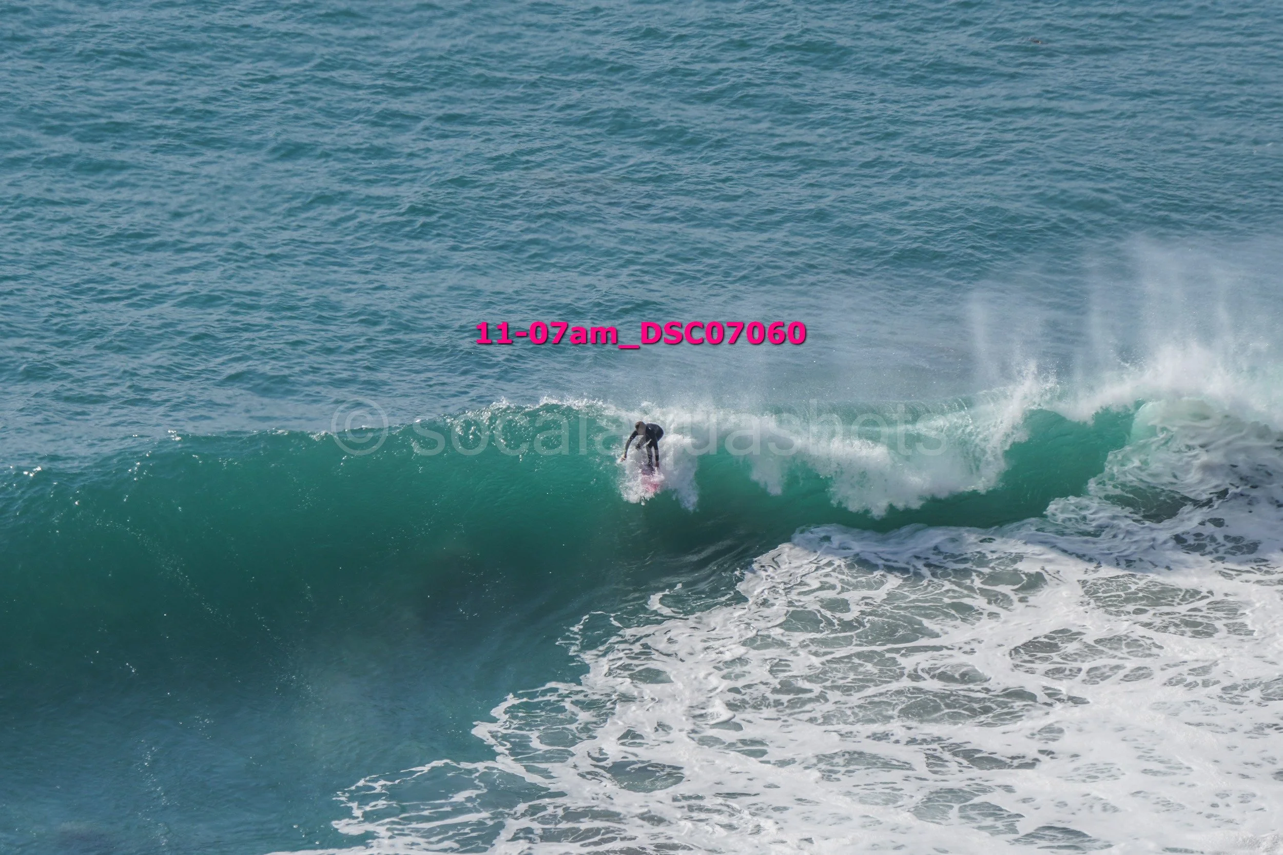 A person surfing on a large wave in the ocean during daytime.