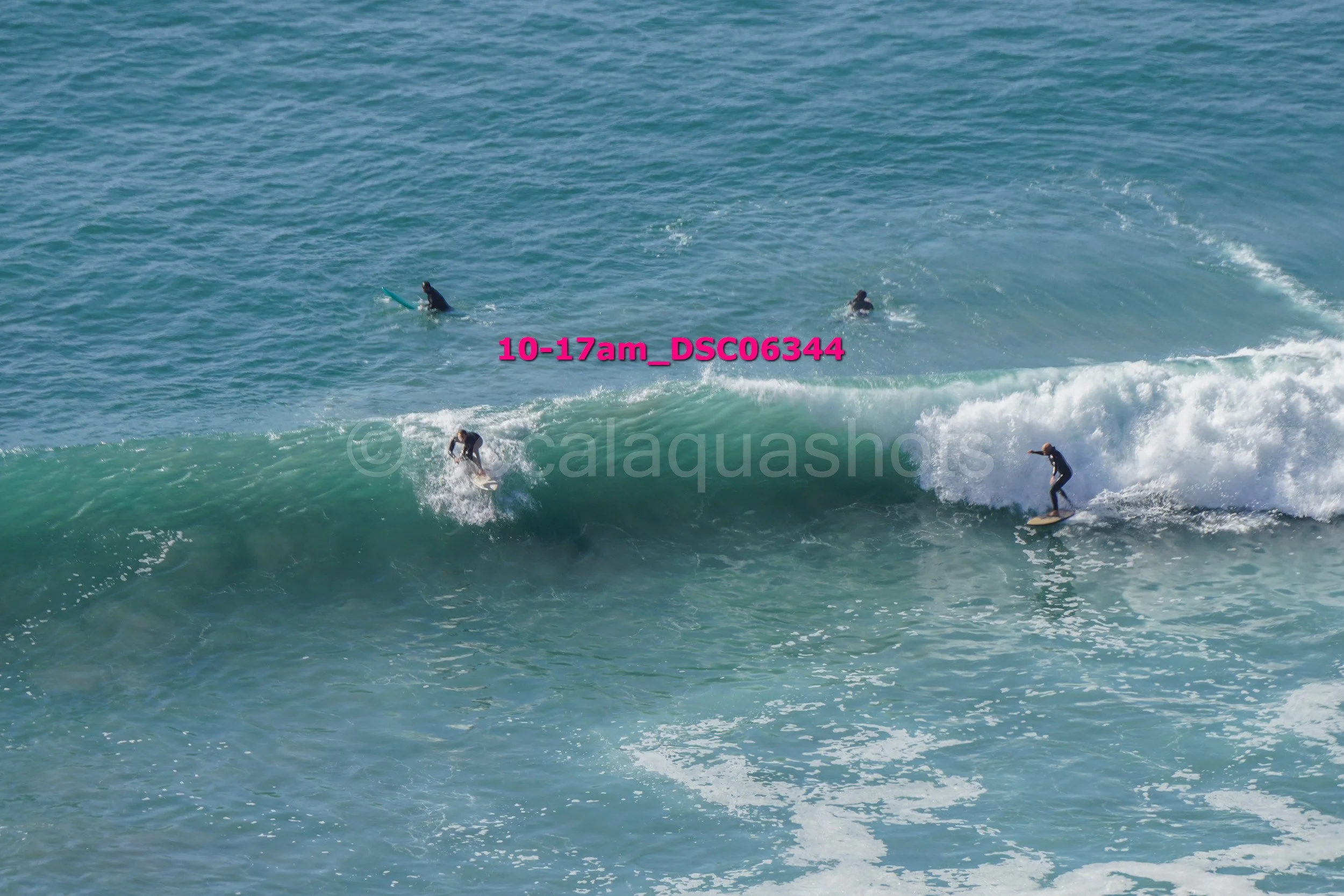 Group of surfers riding and paddling on ocean waves.