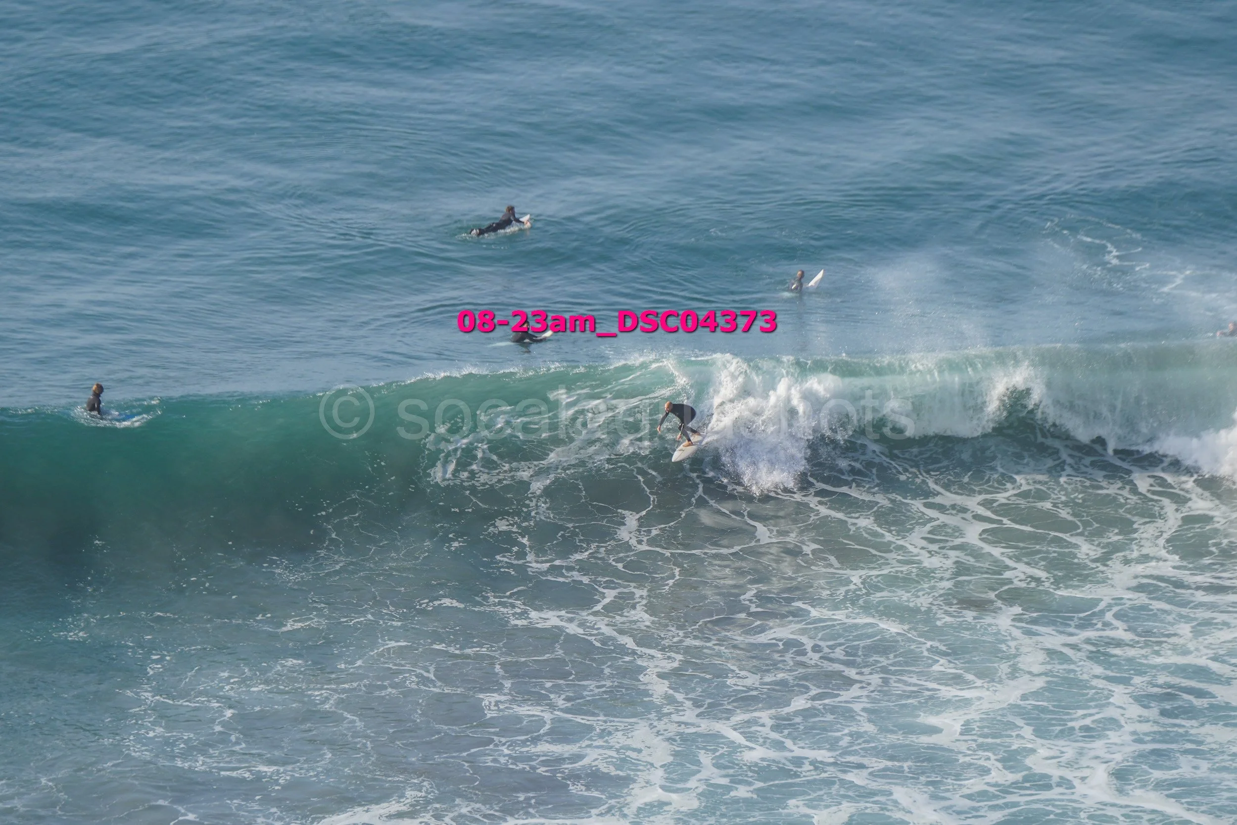 Surfer riding a wave with several surfers in the water nearby