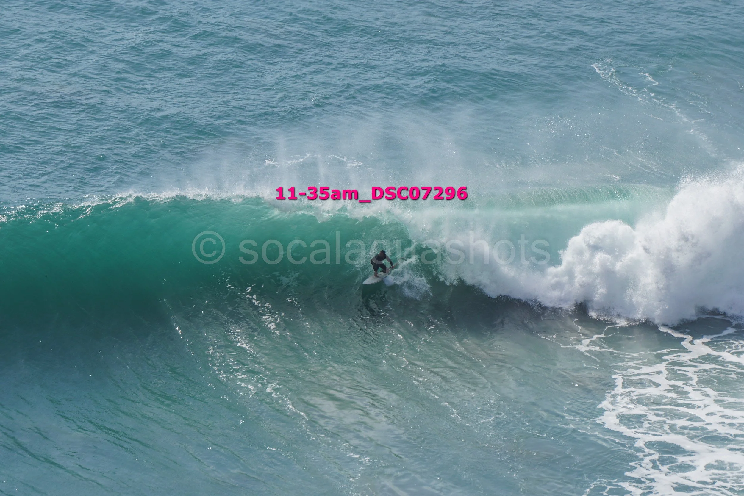 A surfer riding inside the barrel of a large ocean wave.