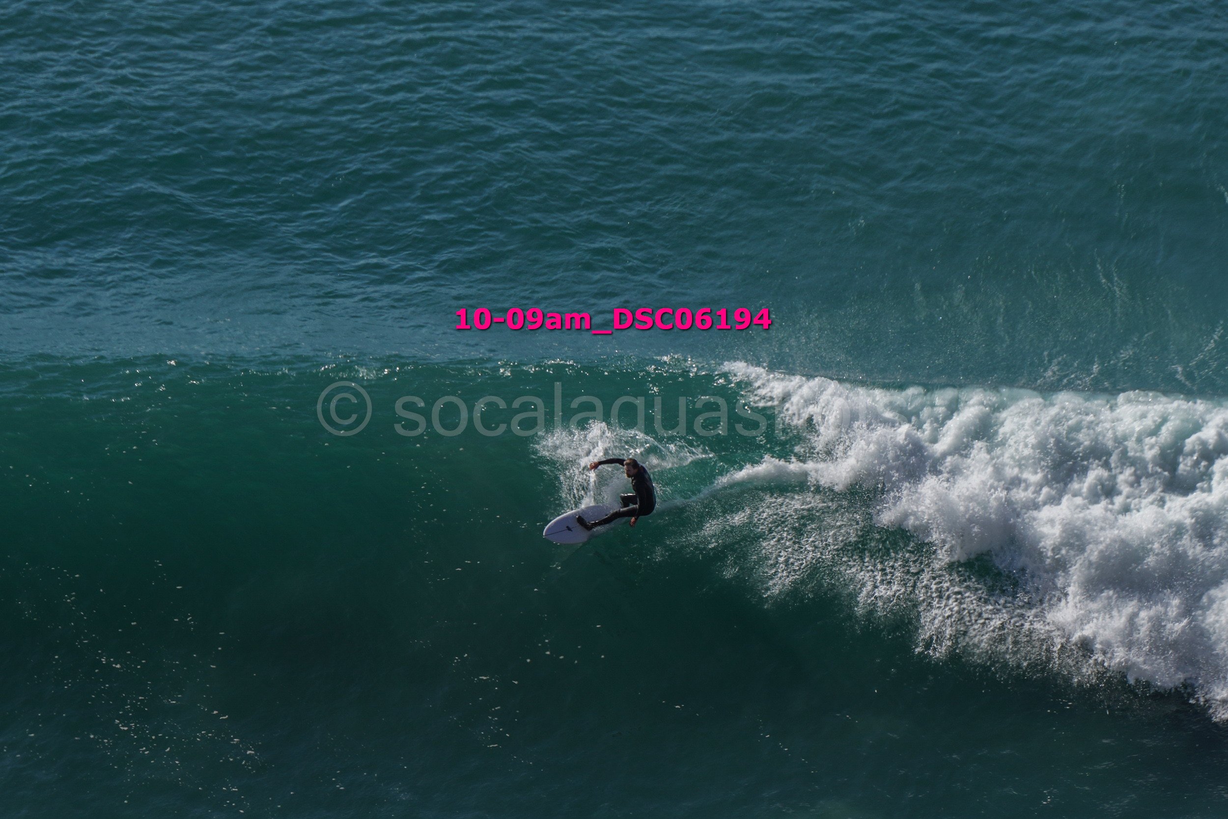 A person surfing on a large wave in the ocean.