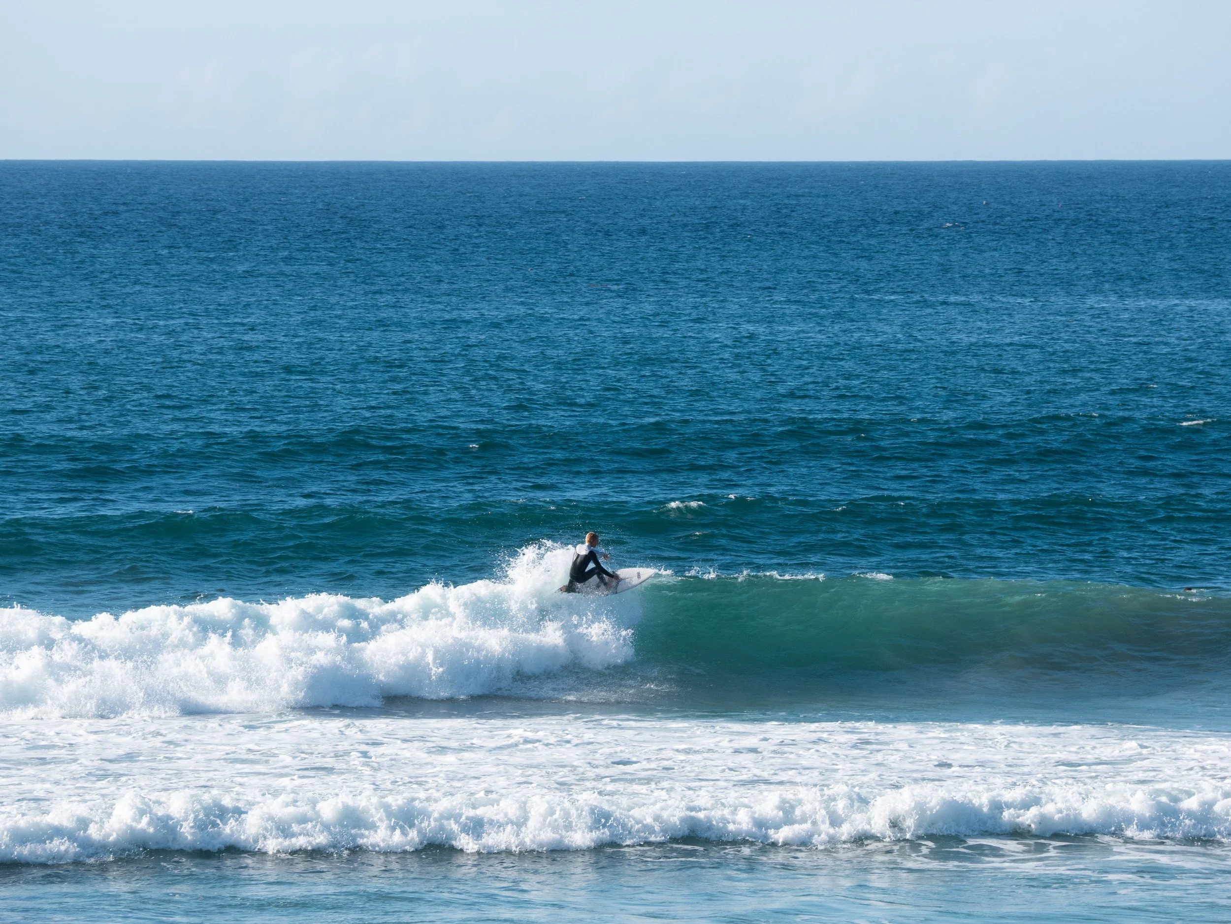 A person surfing on a wave in the ocean.