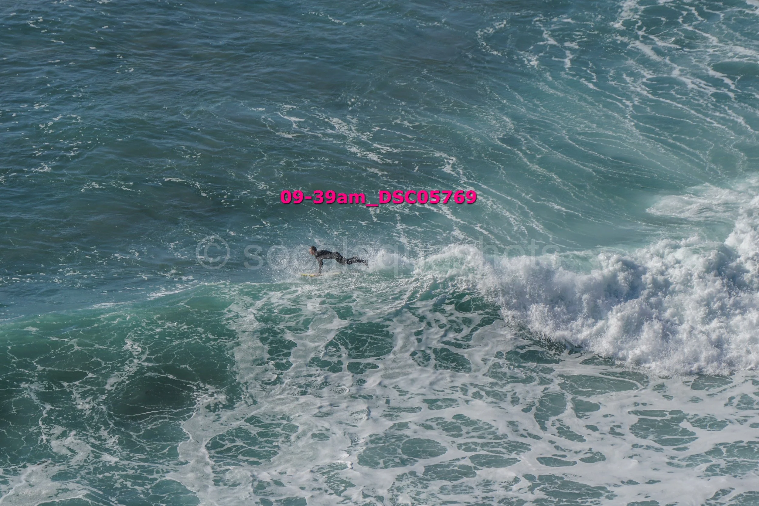 A person surfing on a wave in the ocean during daytime.