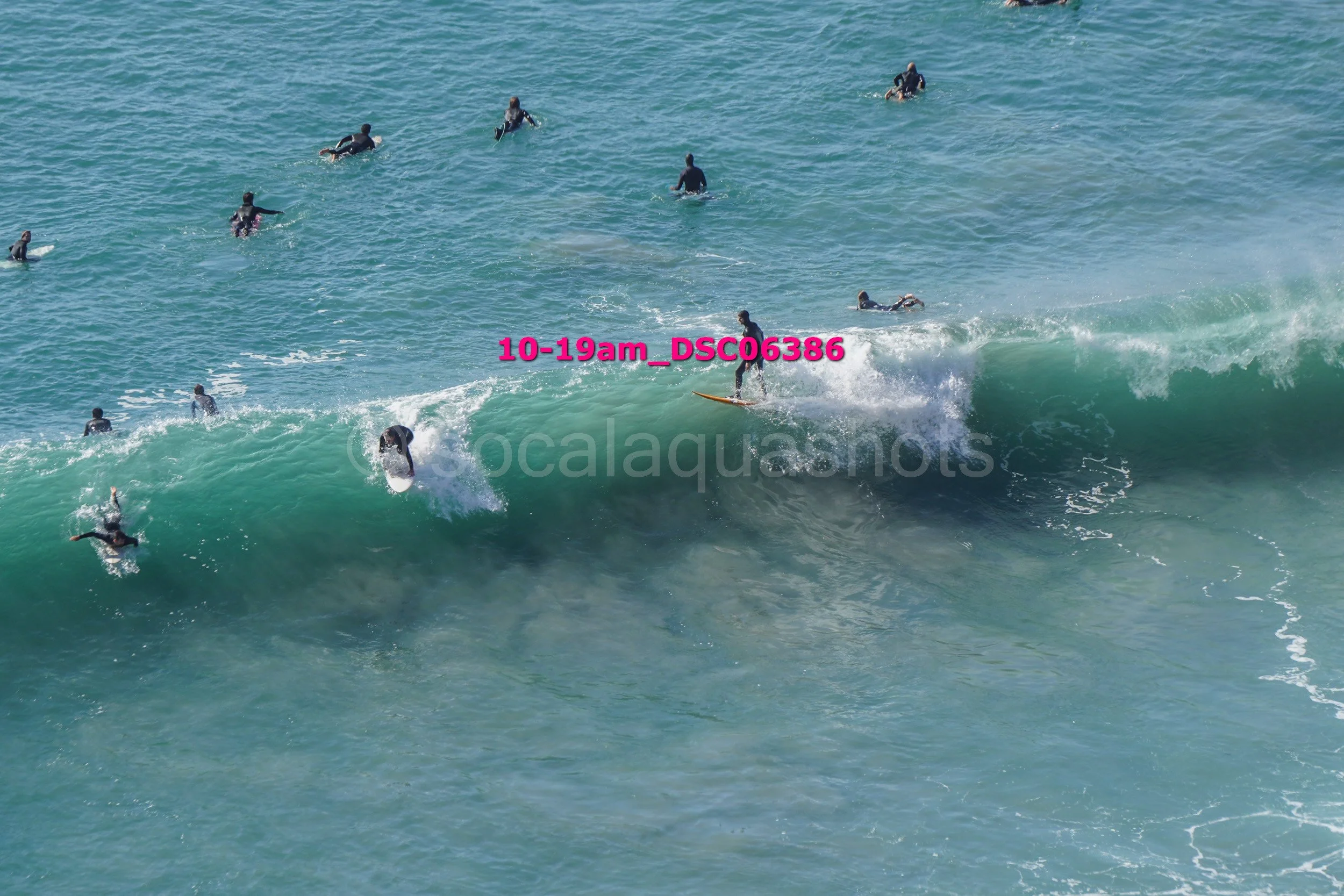 Surfers riding a large wave in the ocean.