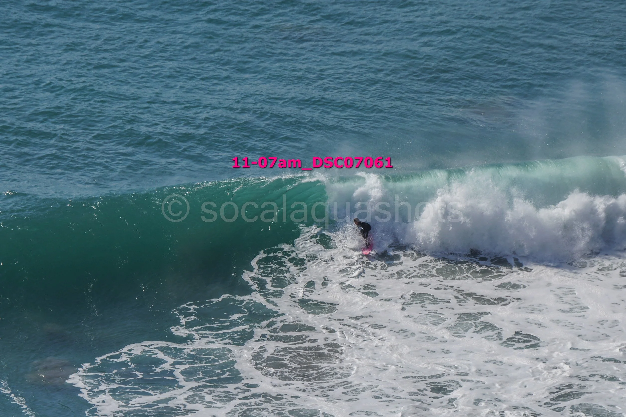 A person surfing on a large wave in the ocean.