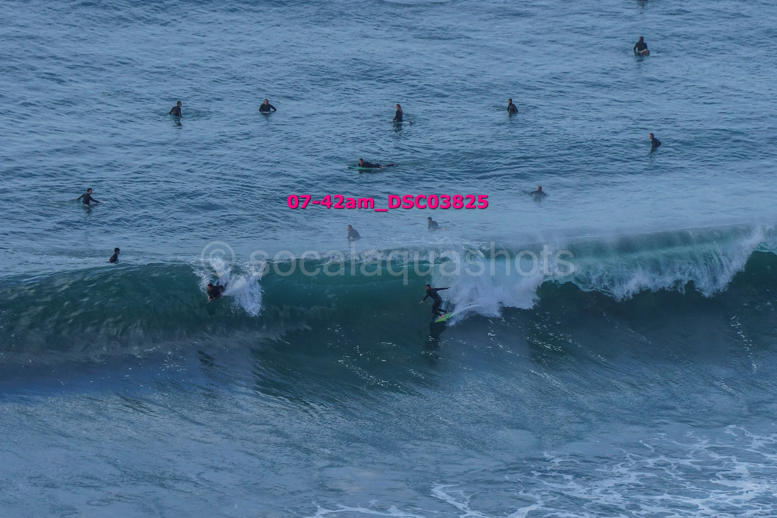 A surfer riding a wave with multiple surfers in the water in the background.