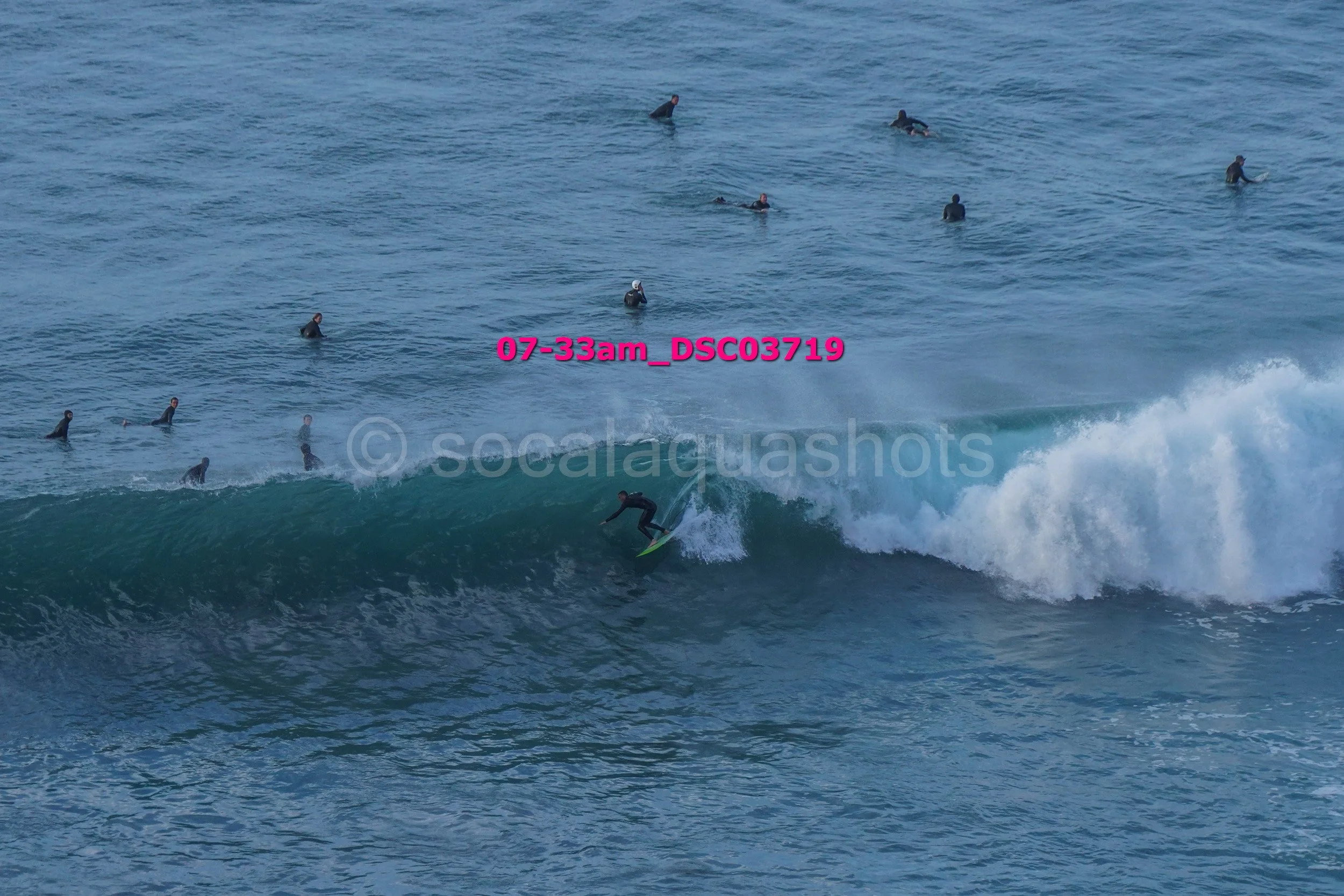 Surfer riding a wave with multiple surfers in the water in the background