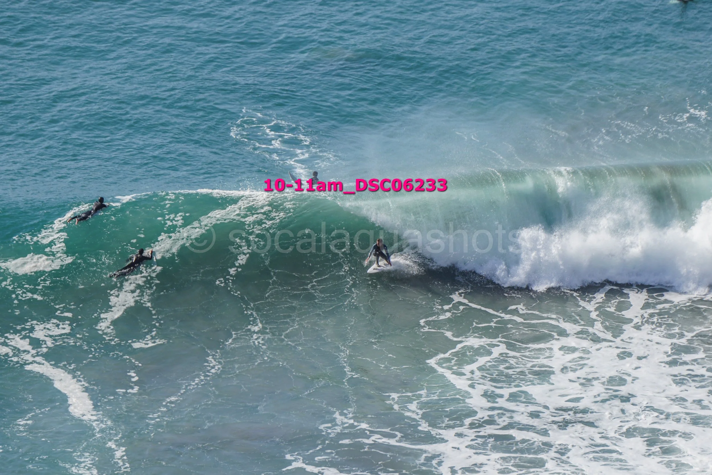 Surfers riding a large wave in the ocean.