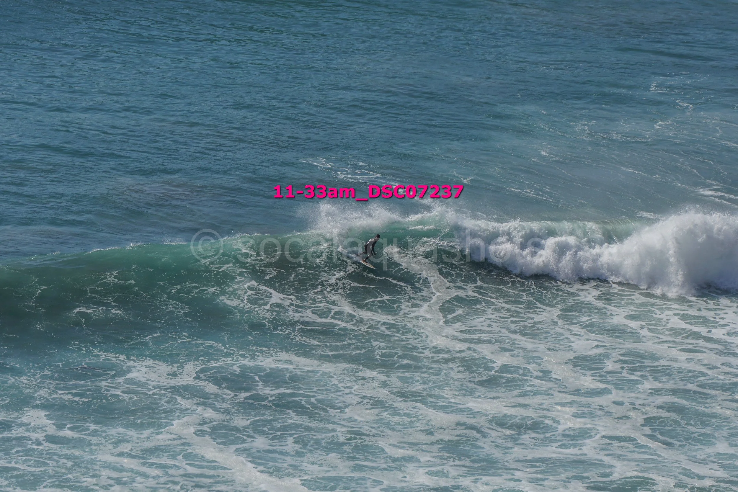 A person surfing on a wave in the ocean during daylight hours.