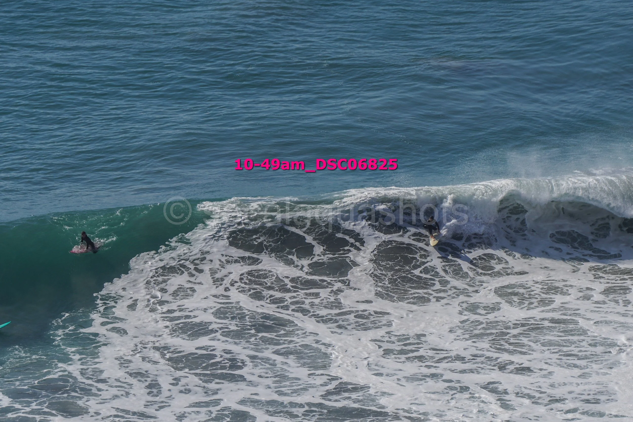 Two surfers riding a large wave in the ocean.