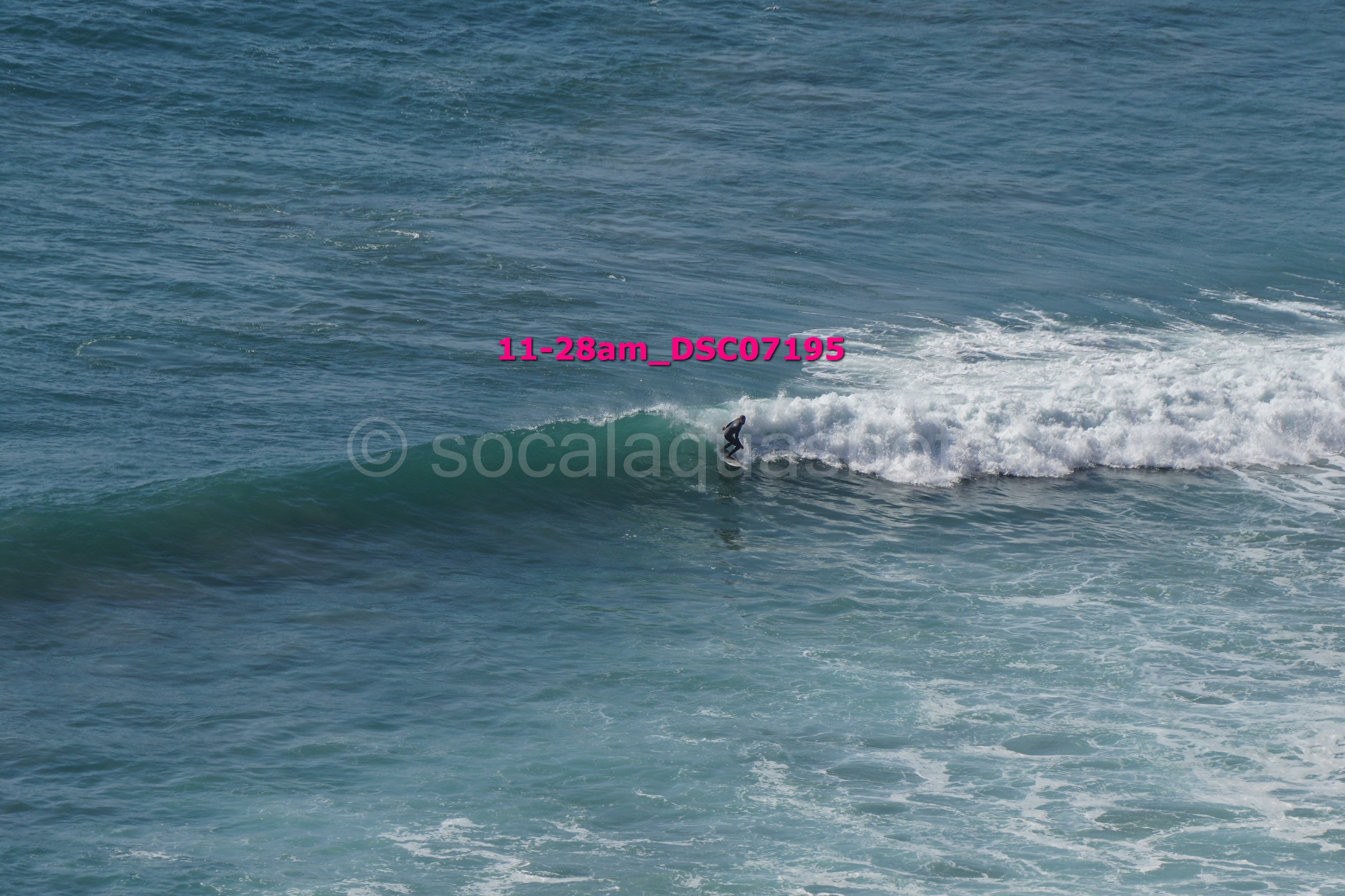 A surfer riding a wave in the ocean during the daytime.