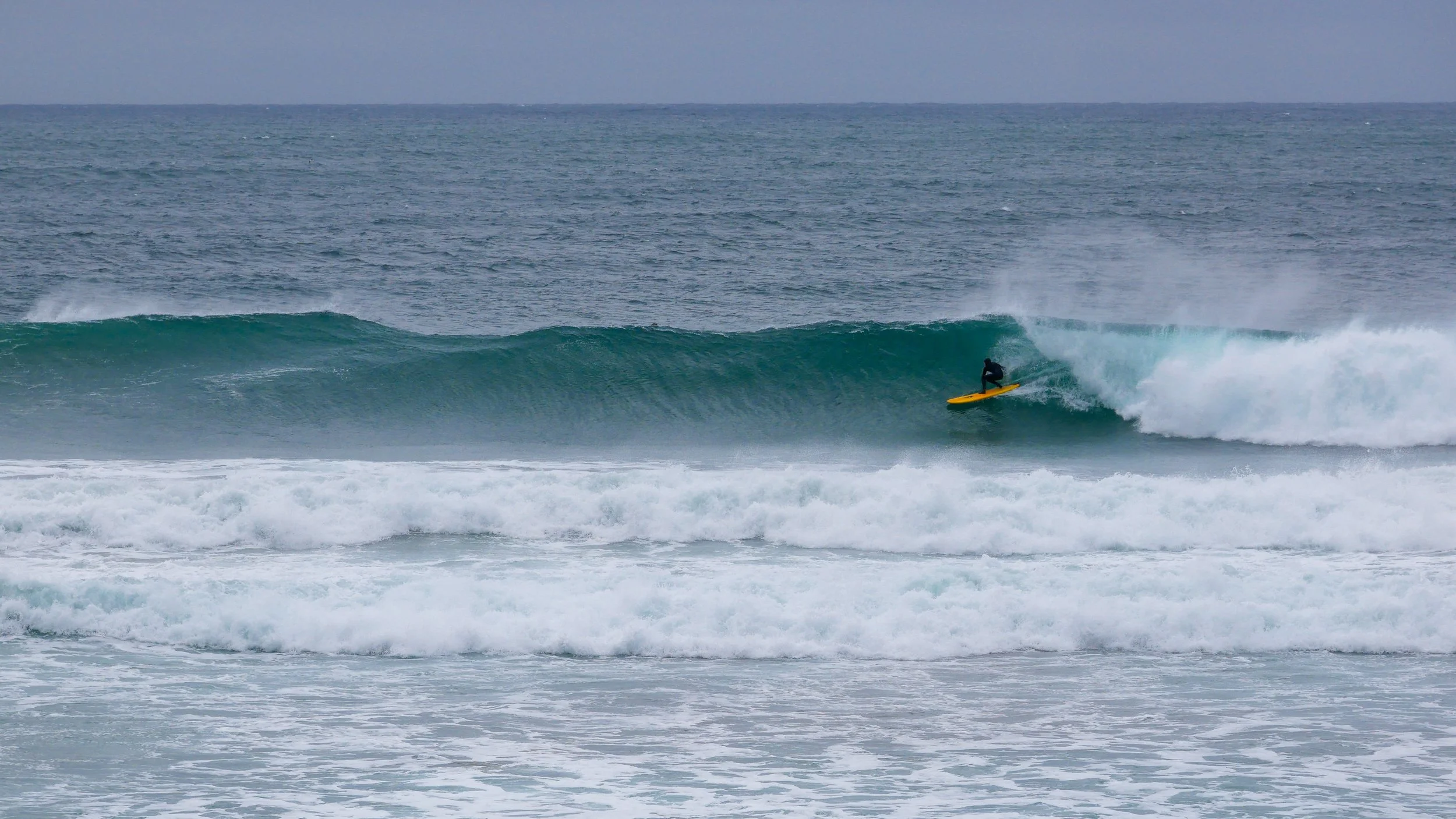 Surfer riding a wave on a surfboard at the ocean