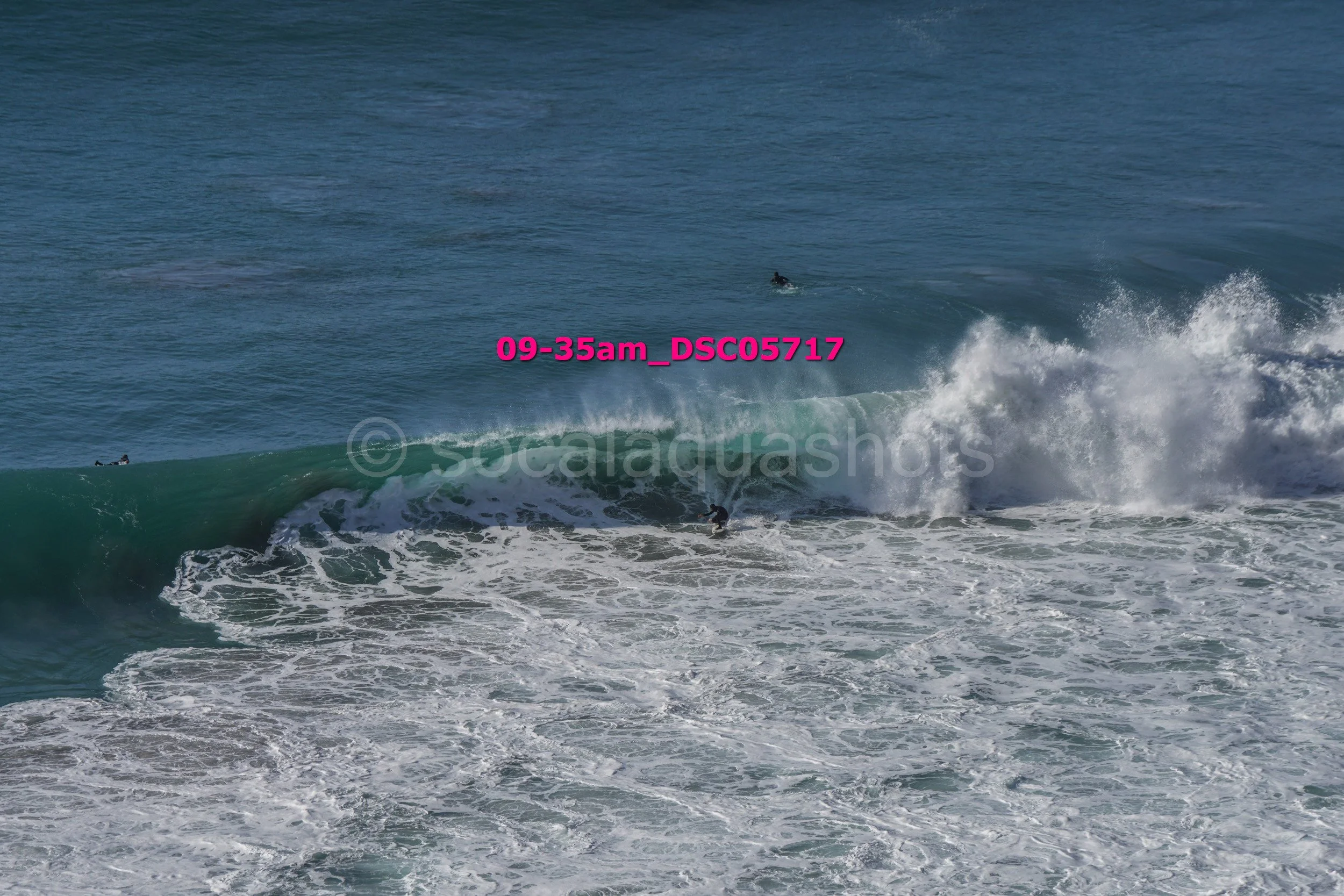People surfing in the ocean with waves and sea spray.