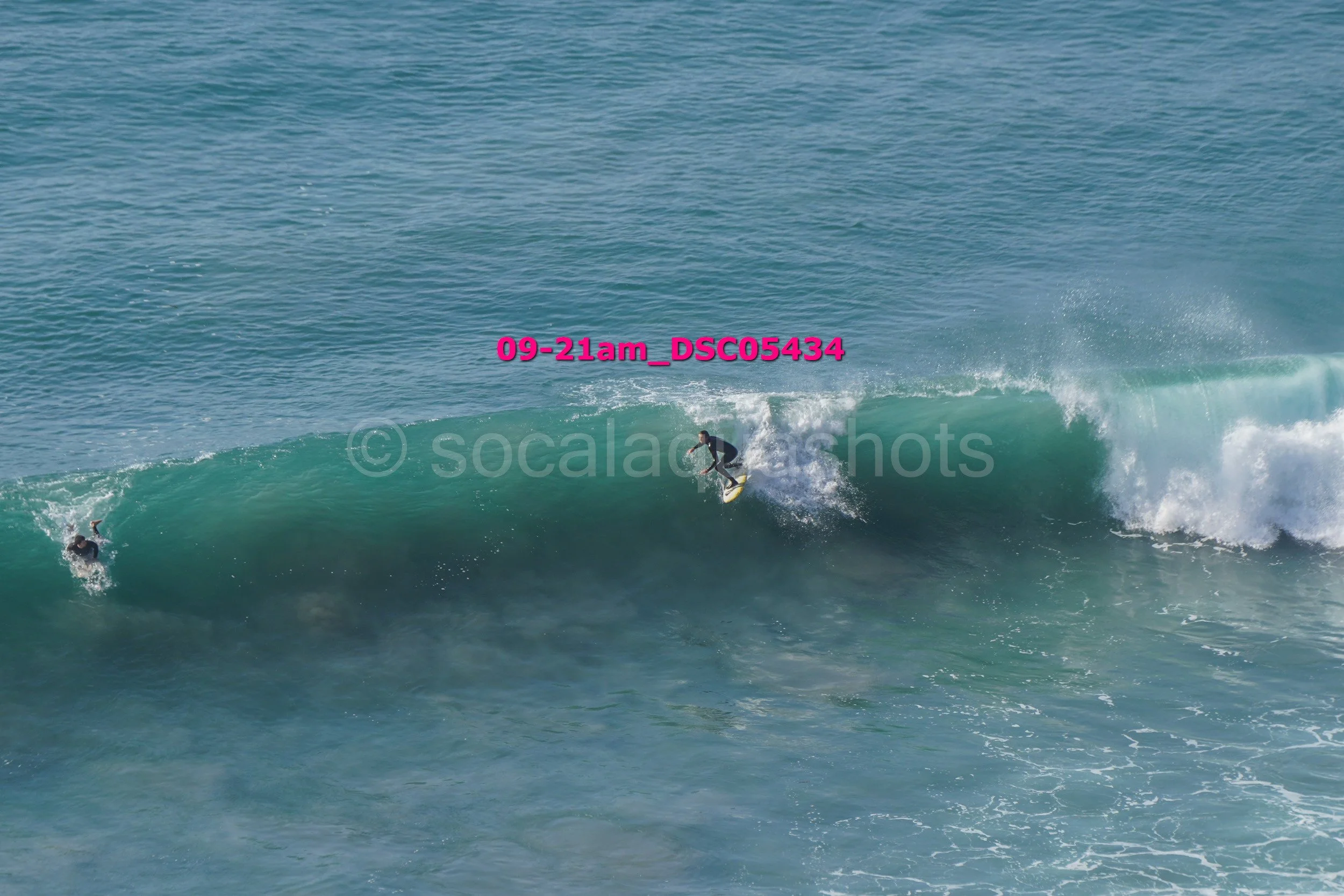 Two surfers riding a large wave in the ocean.