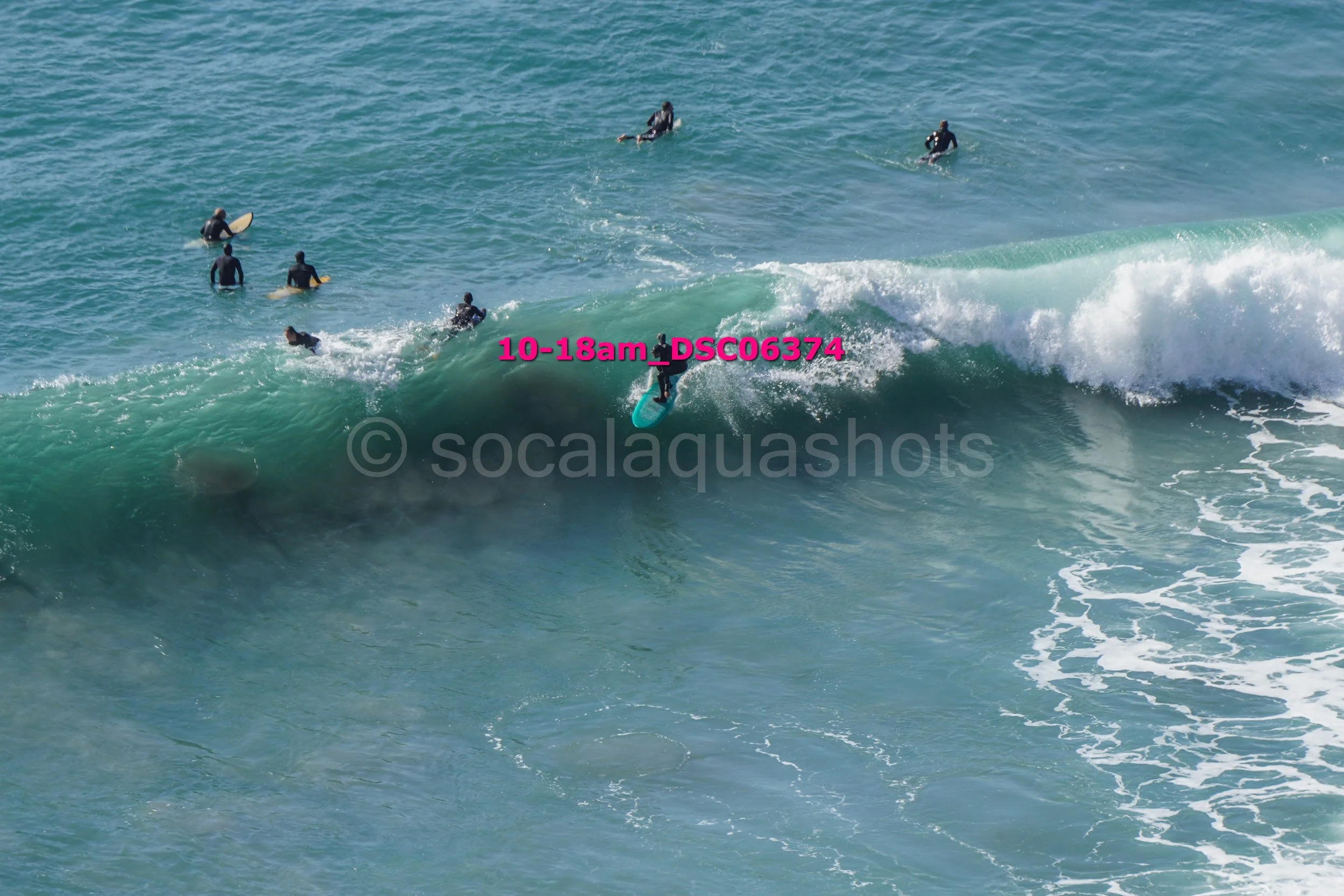 Surfer riding a wave with several surfers in the water nearby