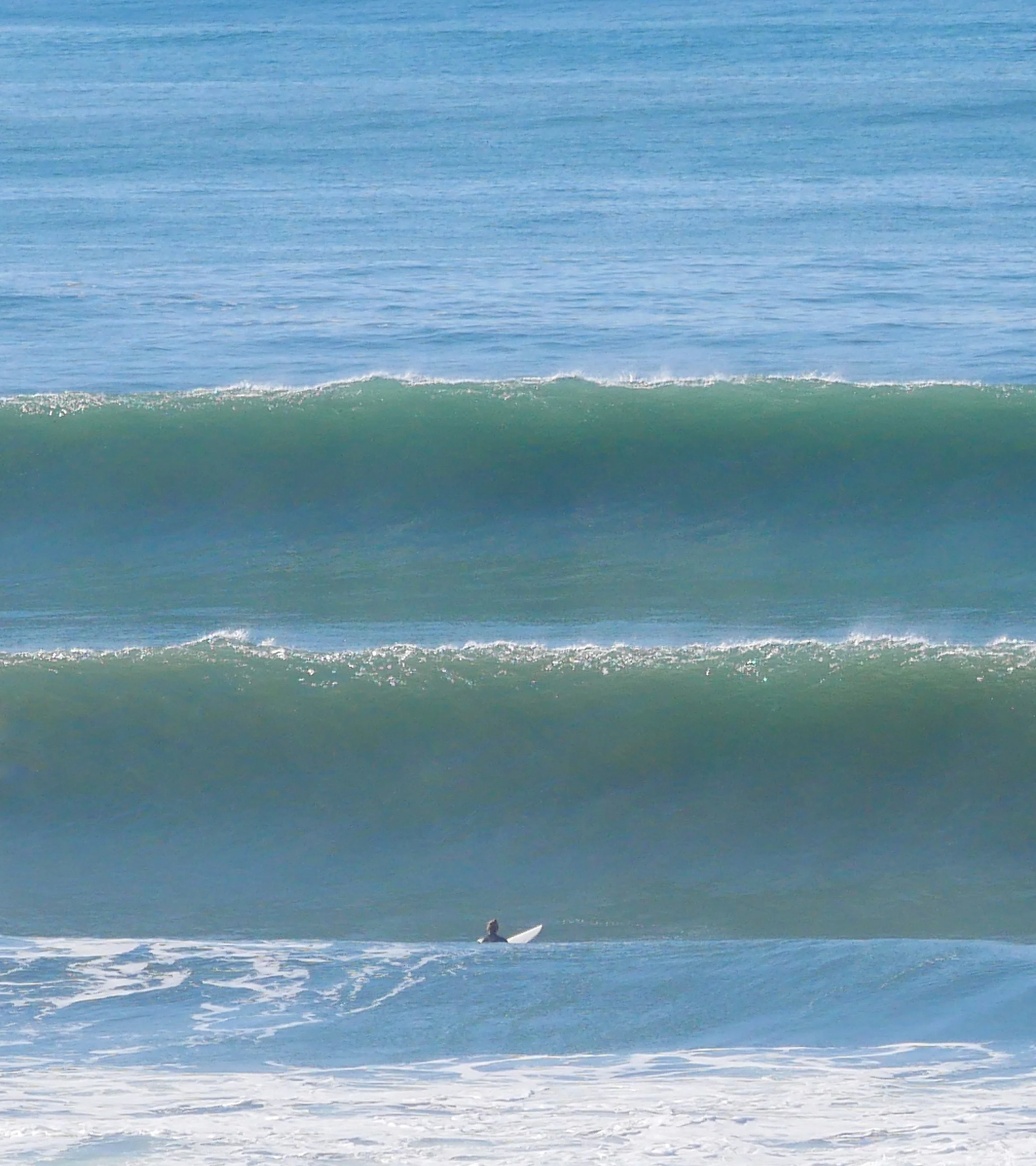 Surfer in ocean with large waves approaching