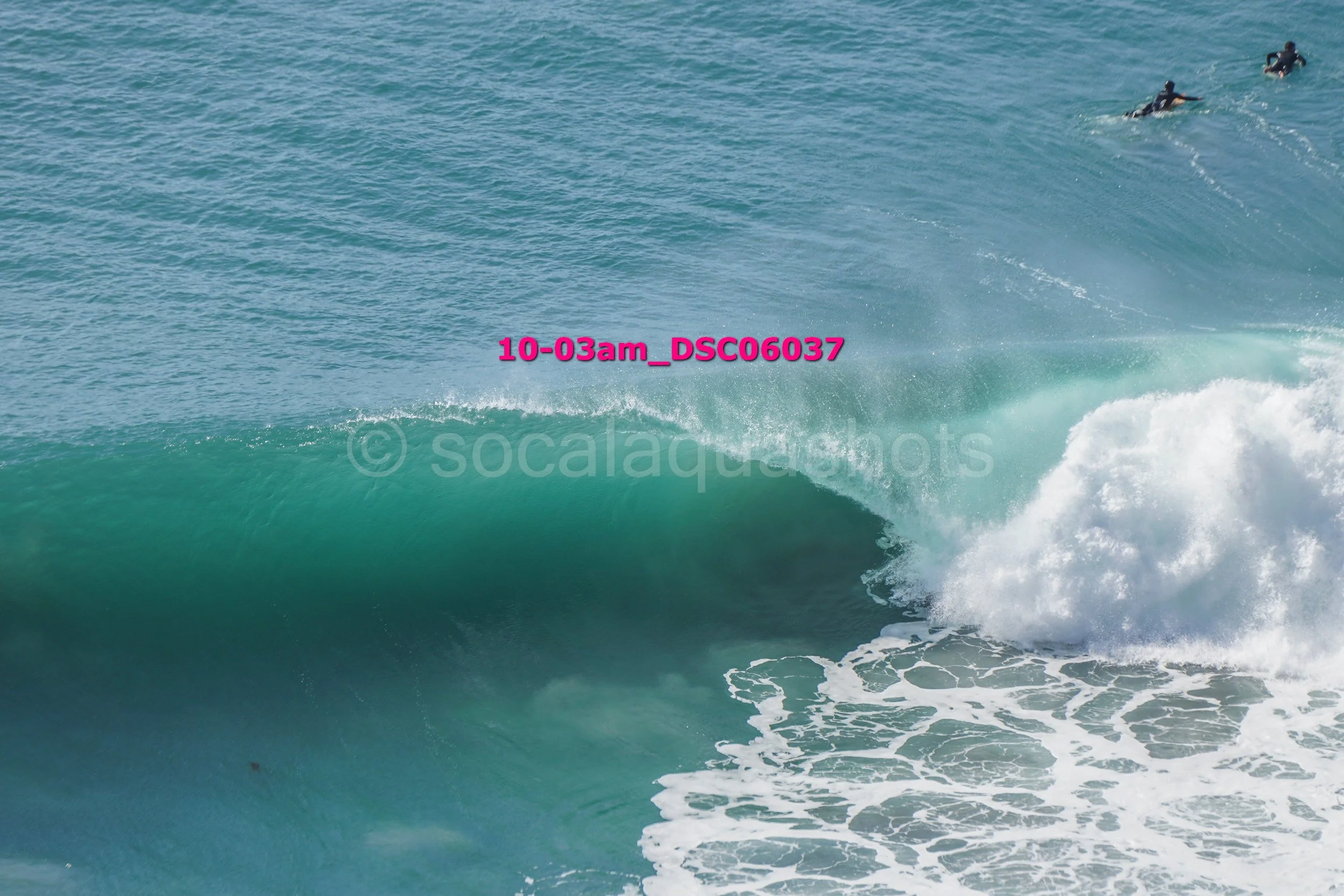Big ocean wave with a surfer riding it, viewed from the side, with the water splashing at the crest.