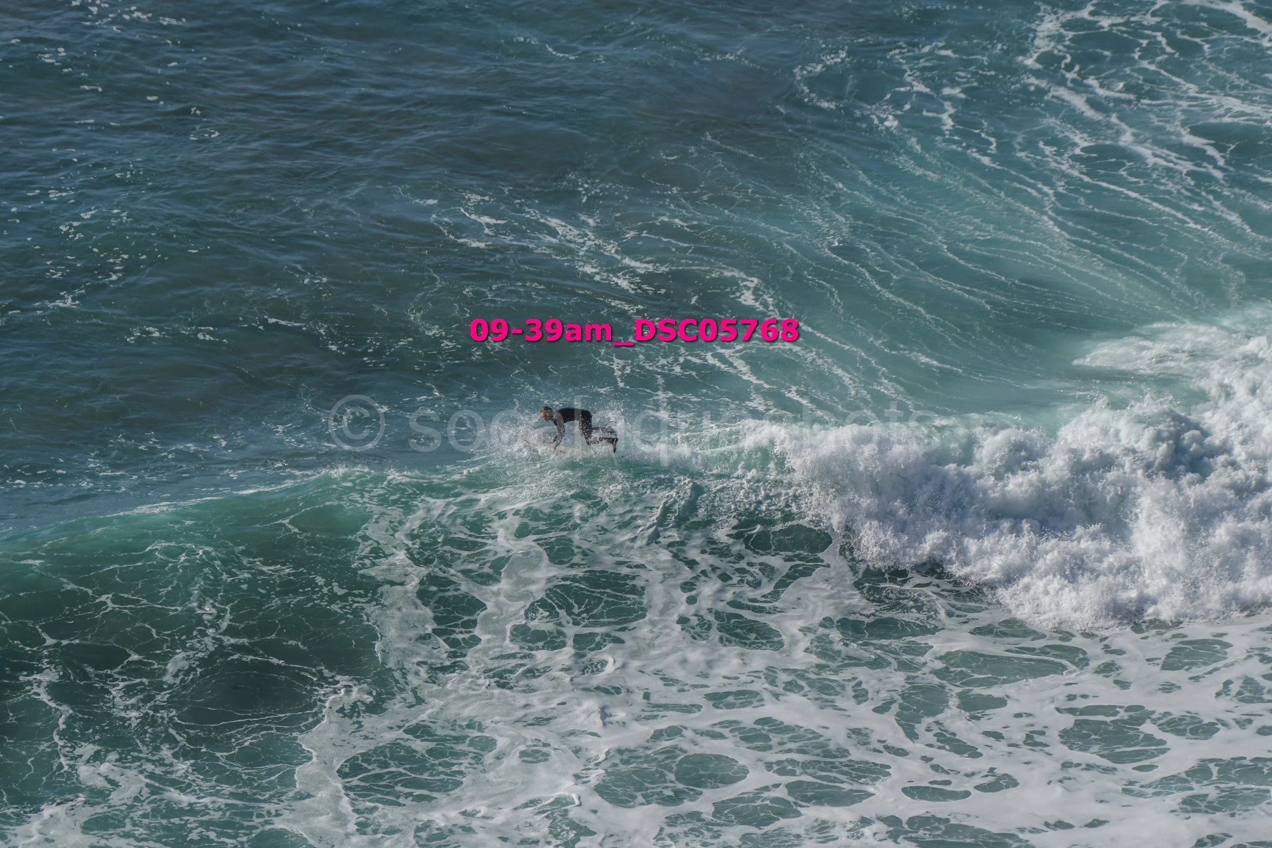 A person surfing in the ocean on a wave.
