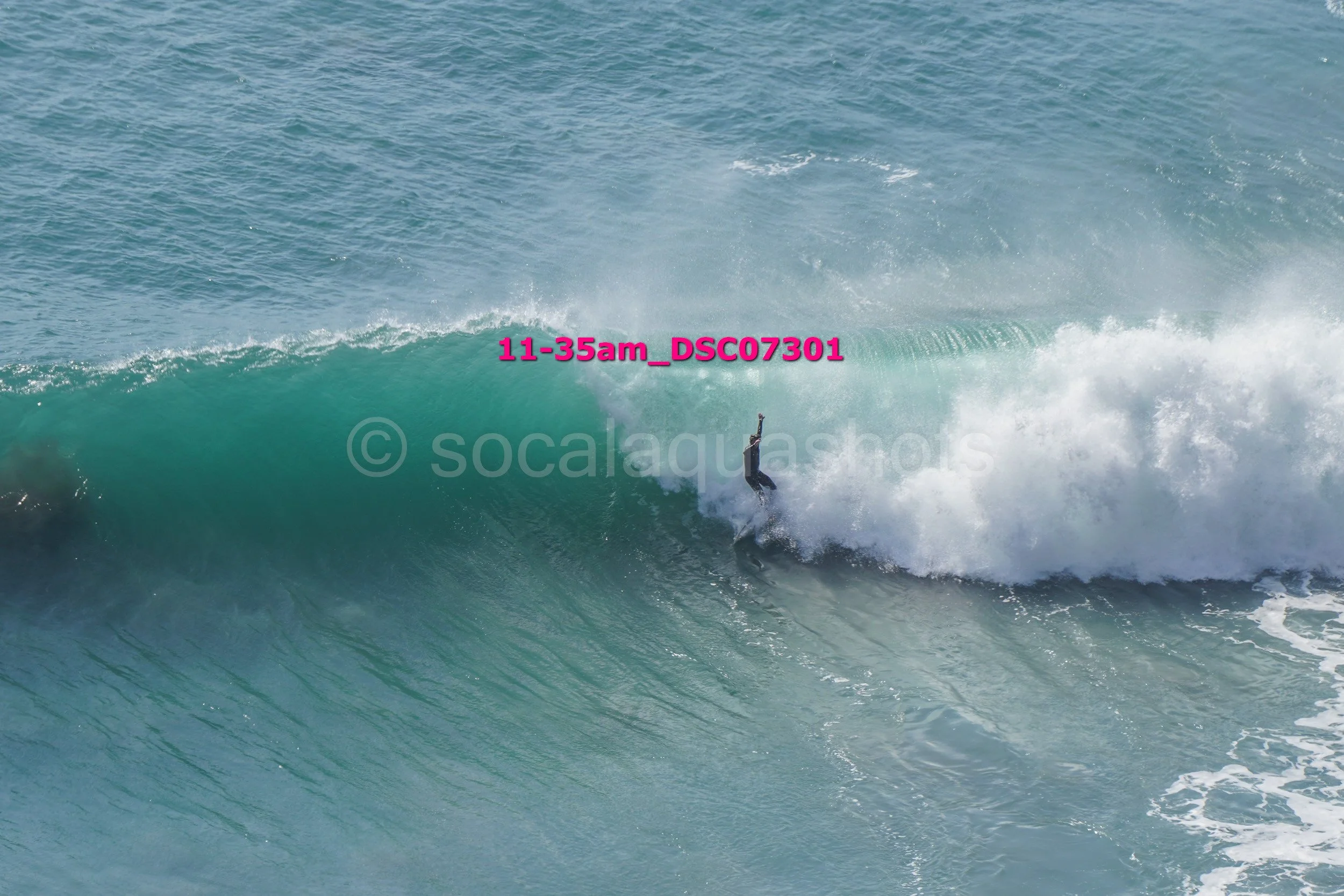 A person surfing on a large wave in the ocean.