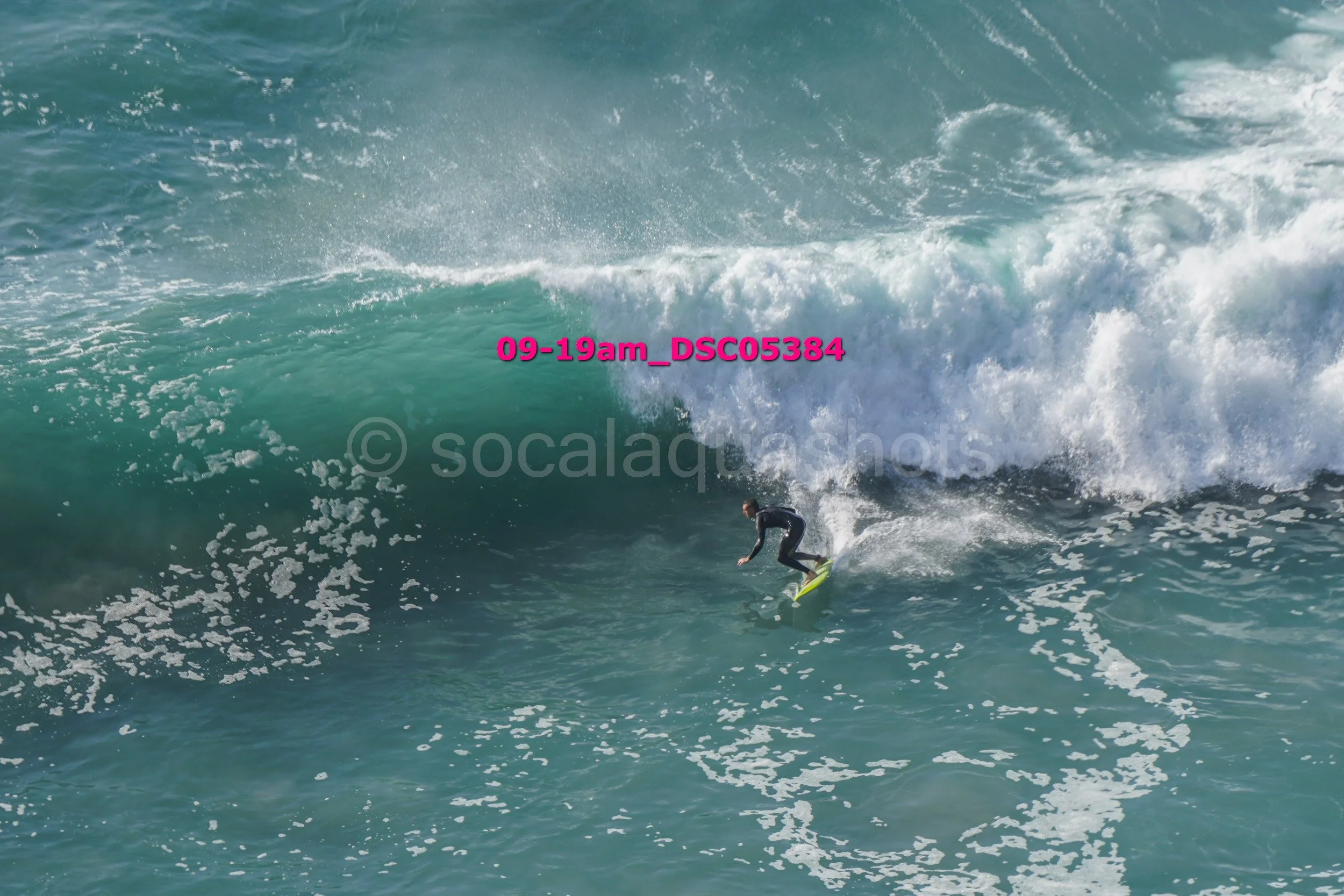A person surfing on a large wave in the ocean.