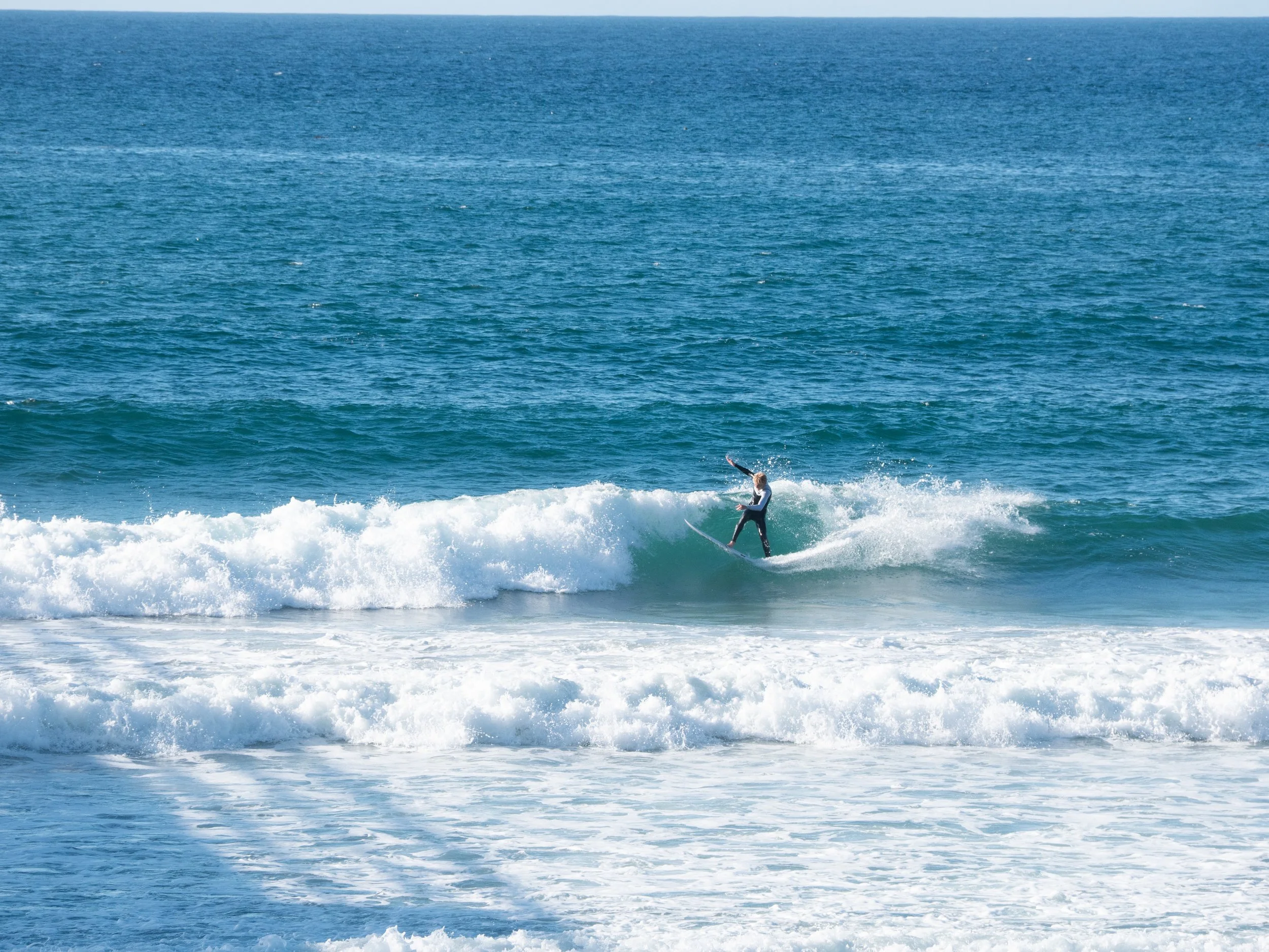 A person surfing on a wave in the ocean.