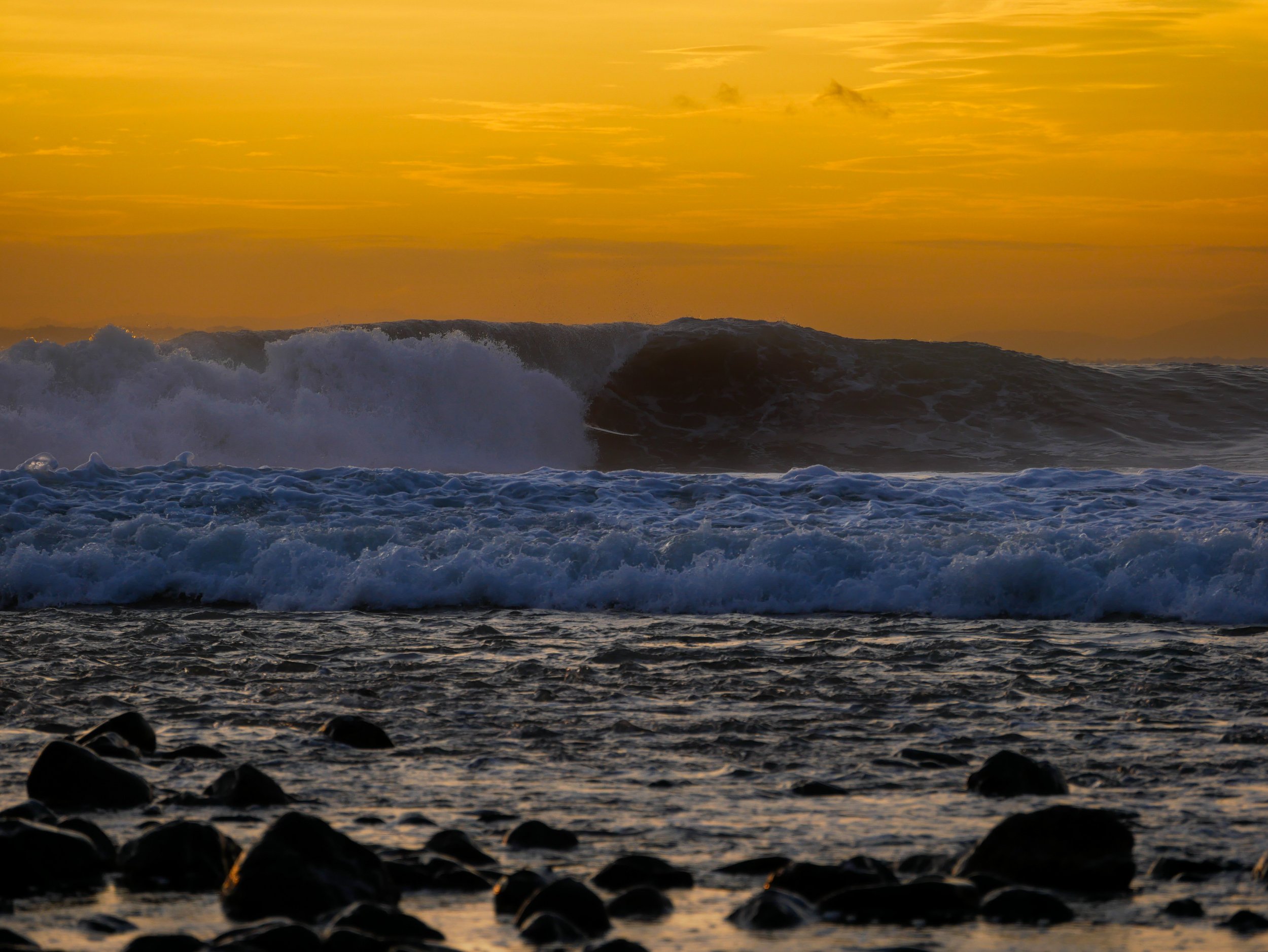 Waves crashing on a rocky shore during sunset