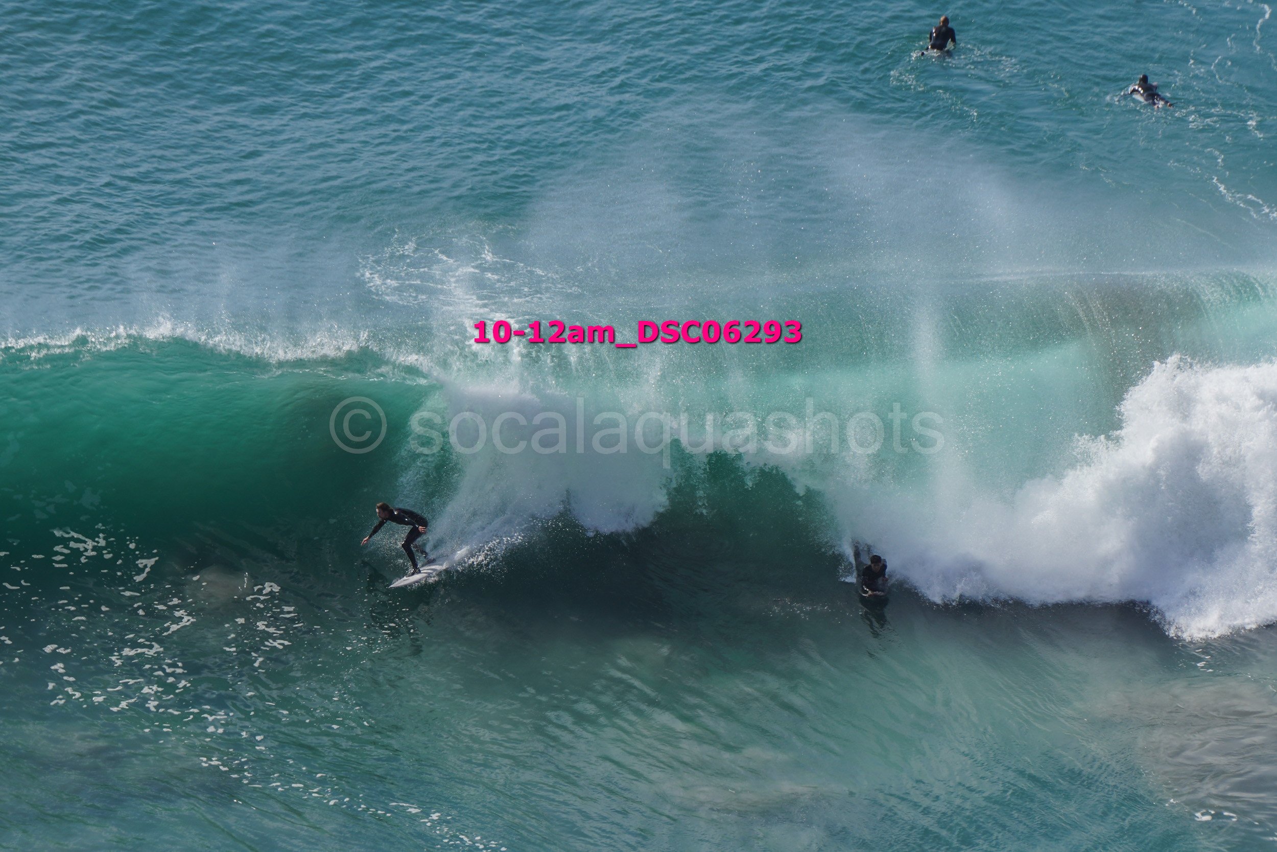 Surfing in the ocean with multiple surfers riding waves and in the water.