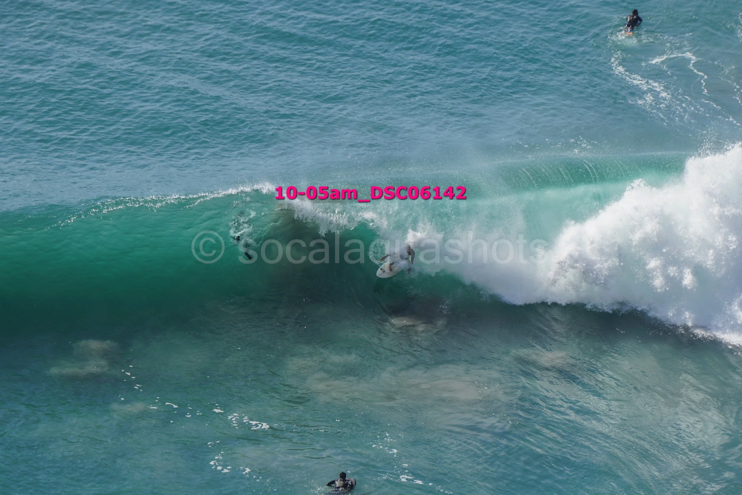 Surfer riding inside a large ocean wave near the shoreline