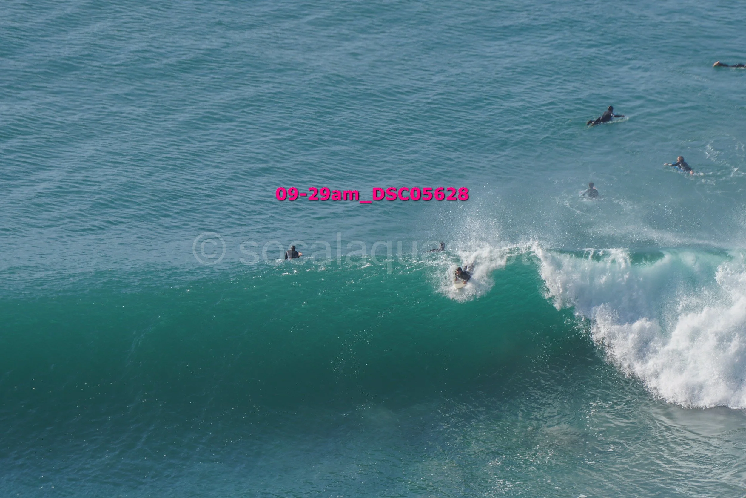 Surfers riding a large wave in the ocean.
