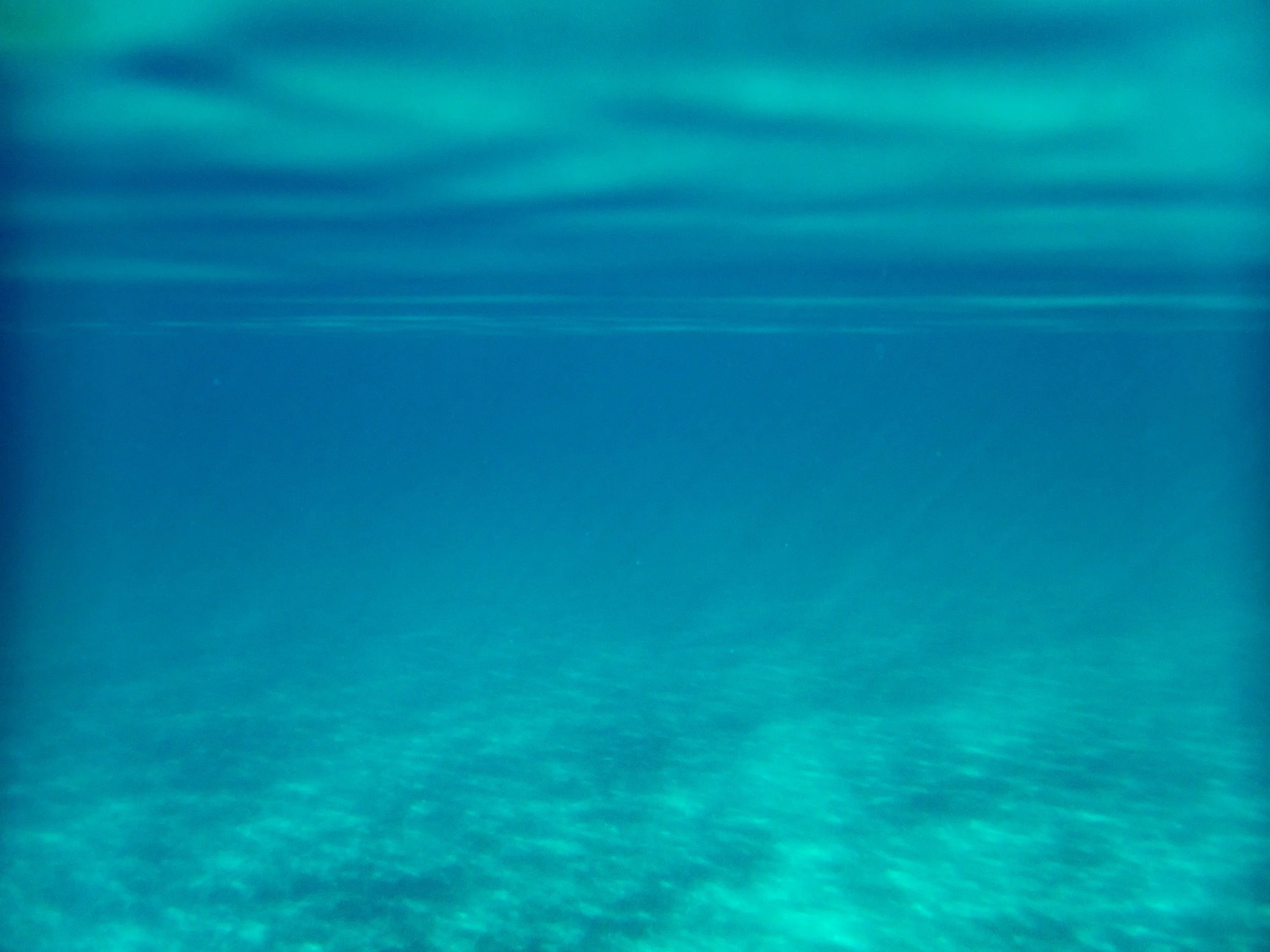 Underwater scene with clear blue water and sunlight rays