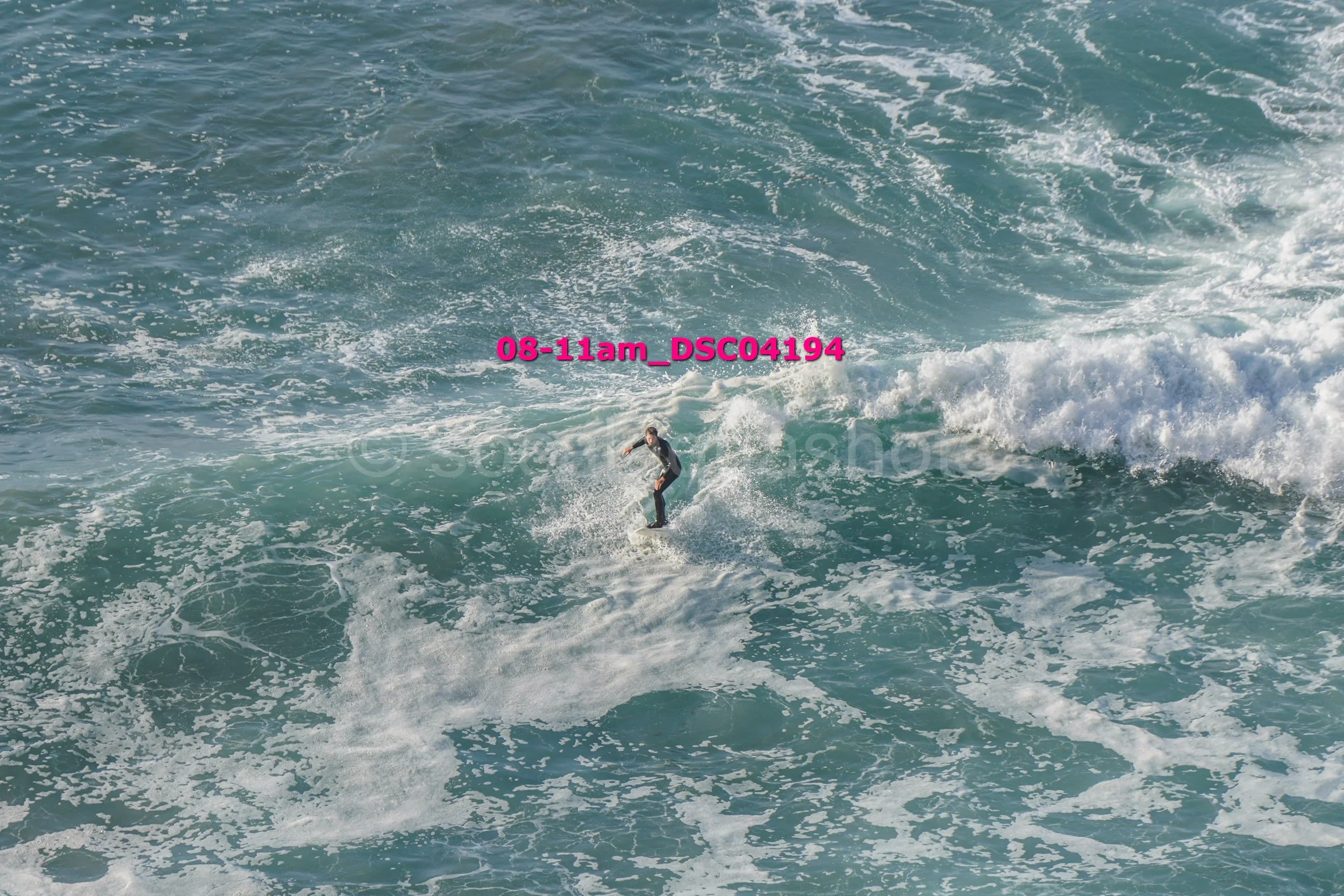 A person surfing on a wave in the ocean during daylight.