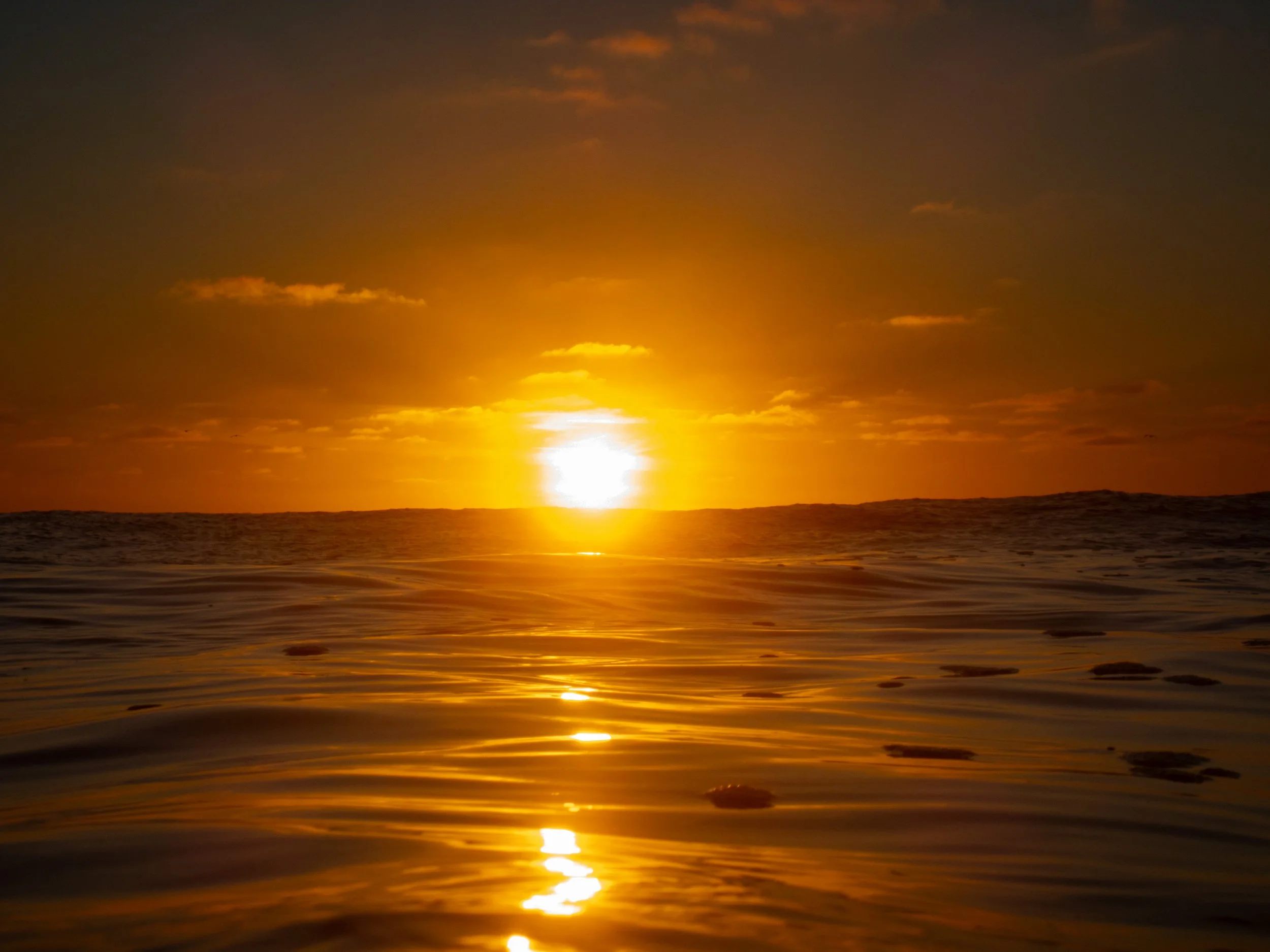 Sunset over the ocean with the reflection on the water.