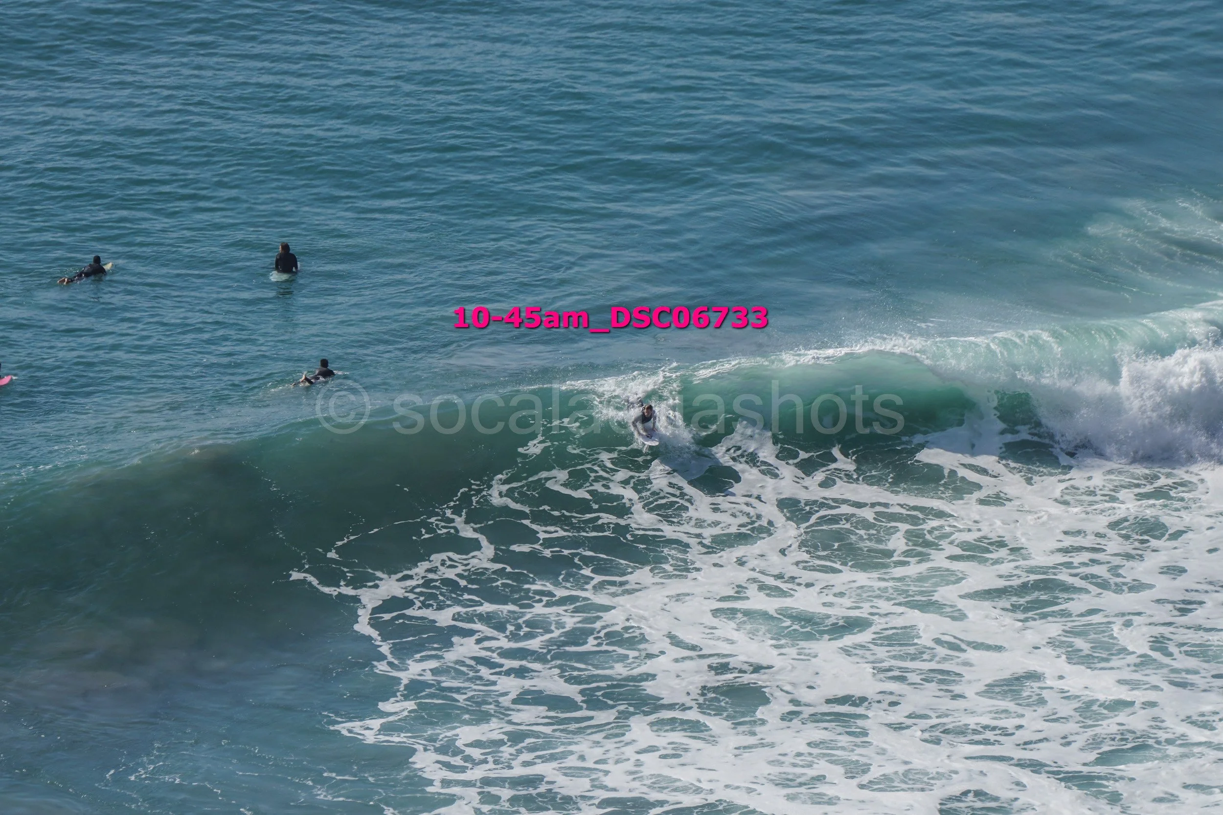 People surfing in the ocean with waves and water spray.