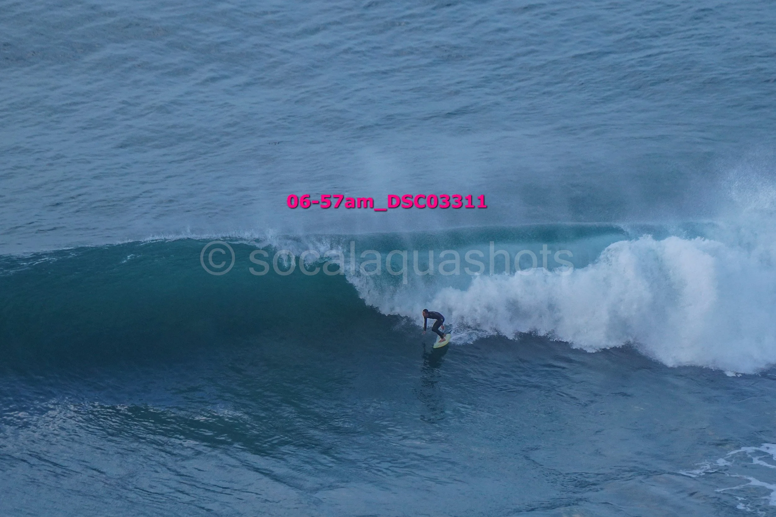 A person surfing on a large ocean wave.