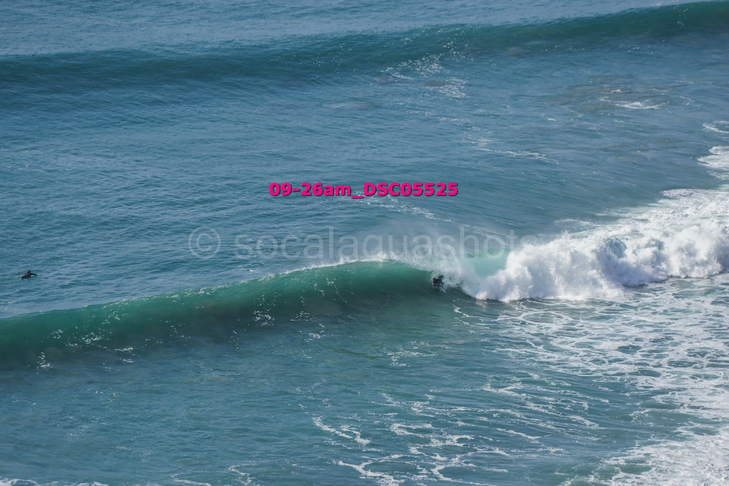 Surfer riding a wave in the ocean, with a watermark and file name over the image.