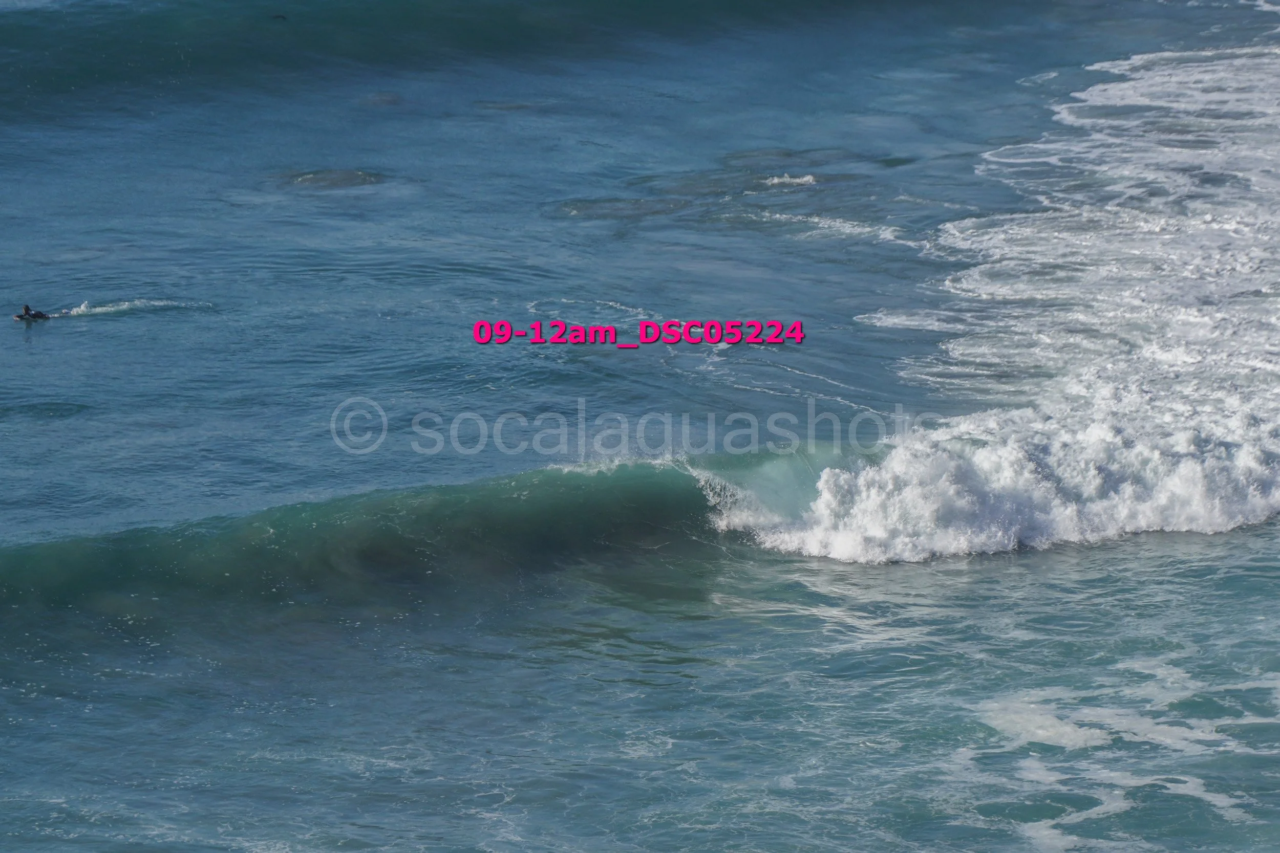 Ocean waves with a surfer in the distance