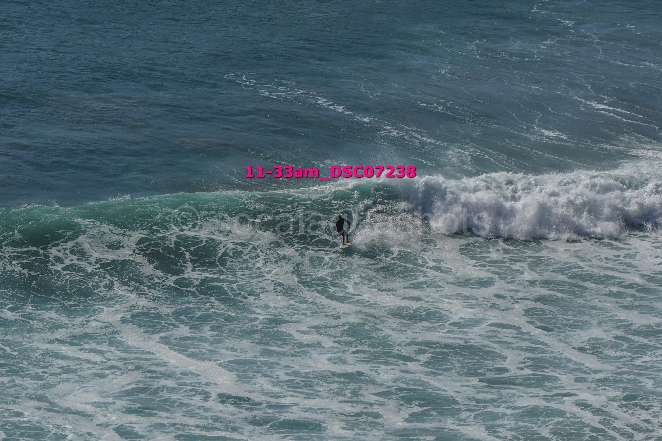 A lone surfer riding a wave in the ocean during daylight.