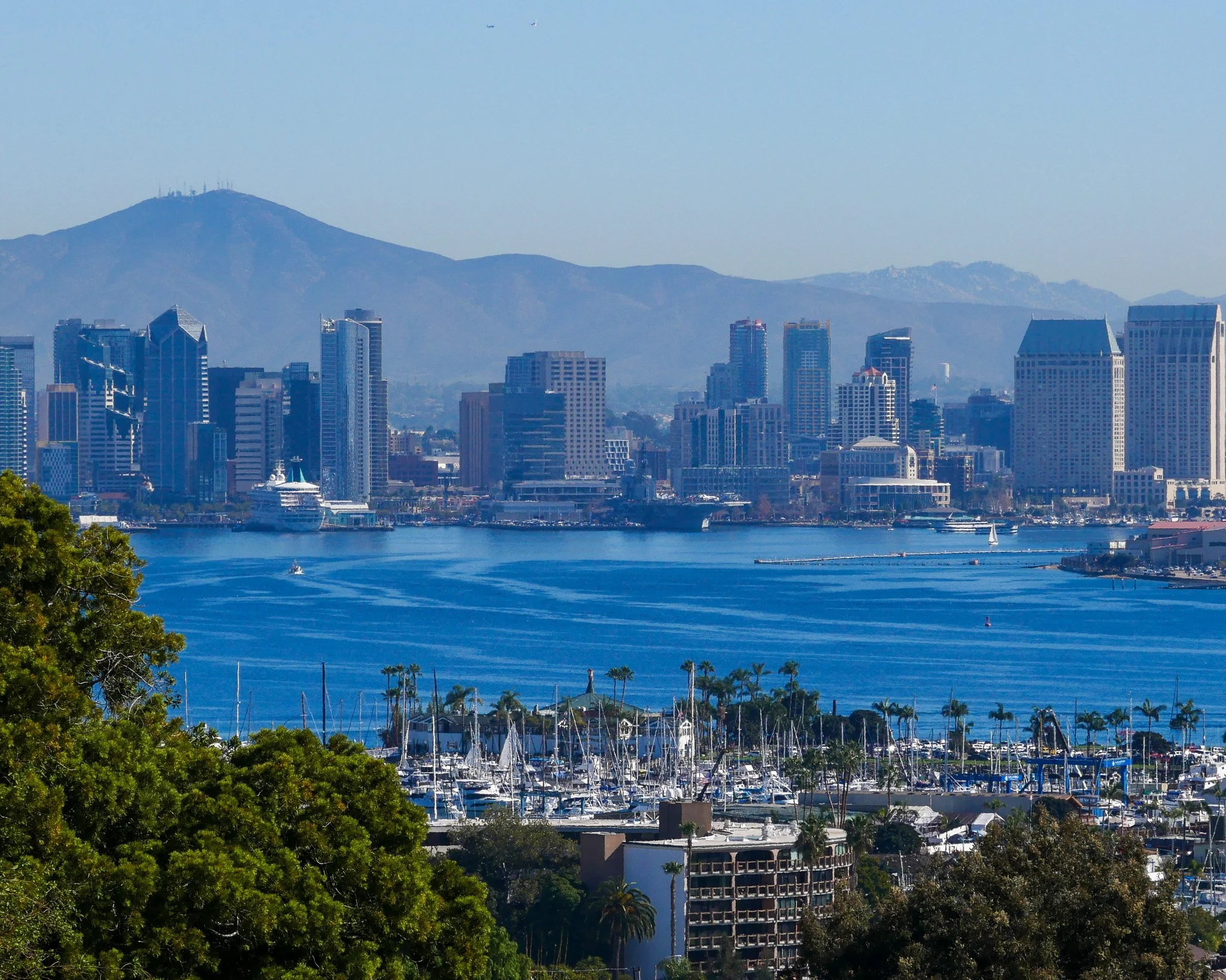 San Diego skyline with mountains, clear sky, and harbor with boats