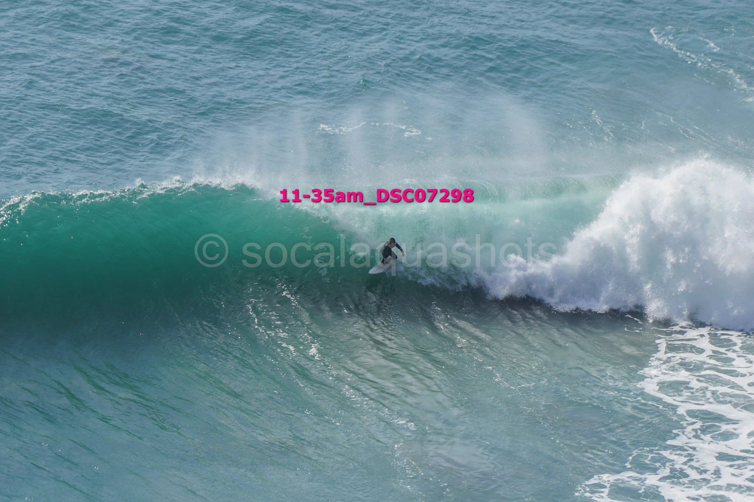 A person surfing on a large wave in the ocean.