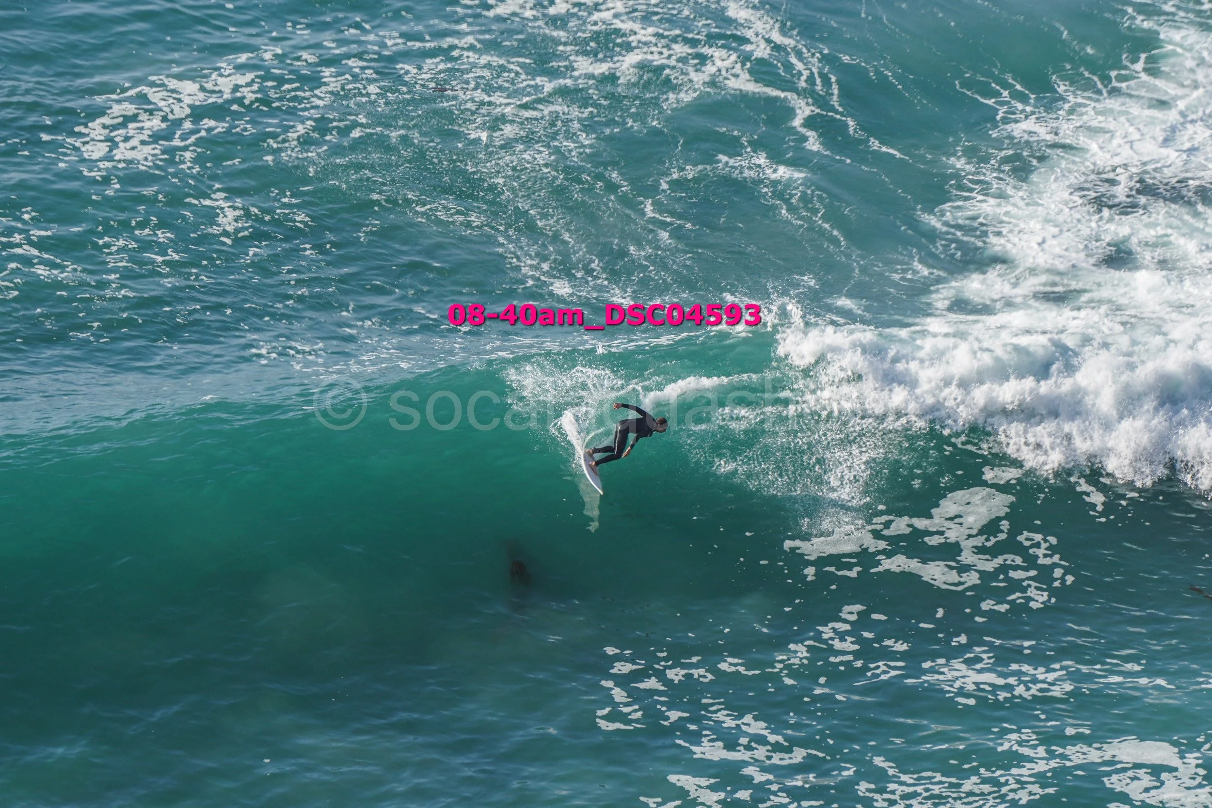 A person in a wetsuit surfing on a wave in the ocean.