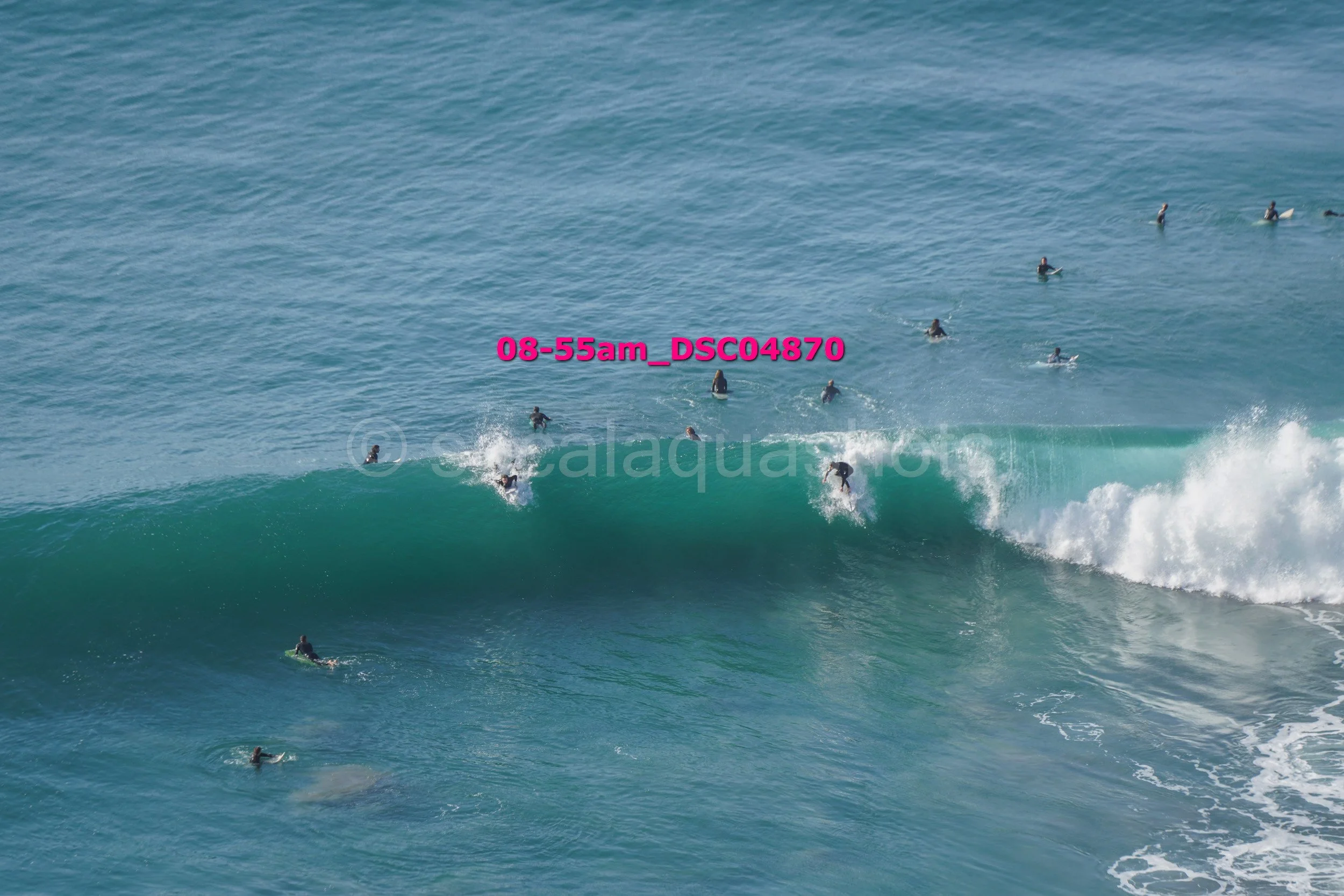 Group of surfers waiting and riding waves in the ocean