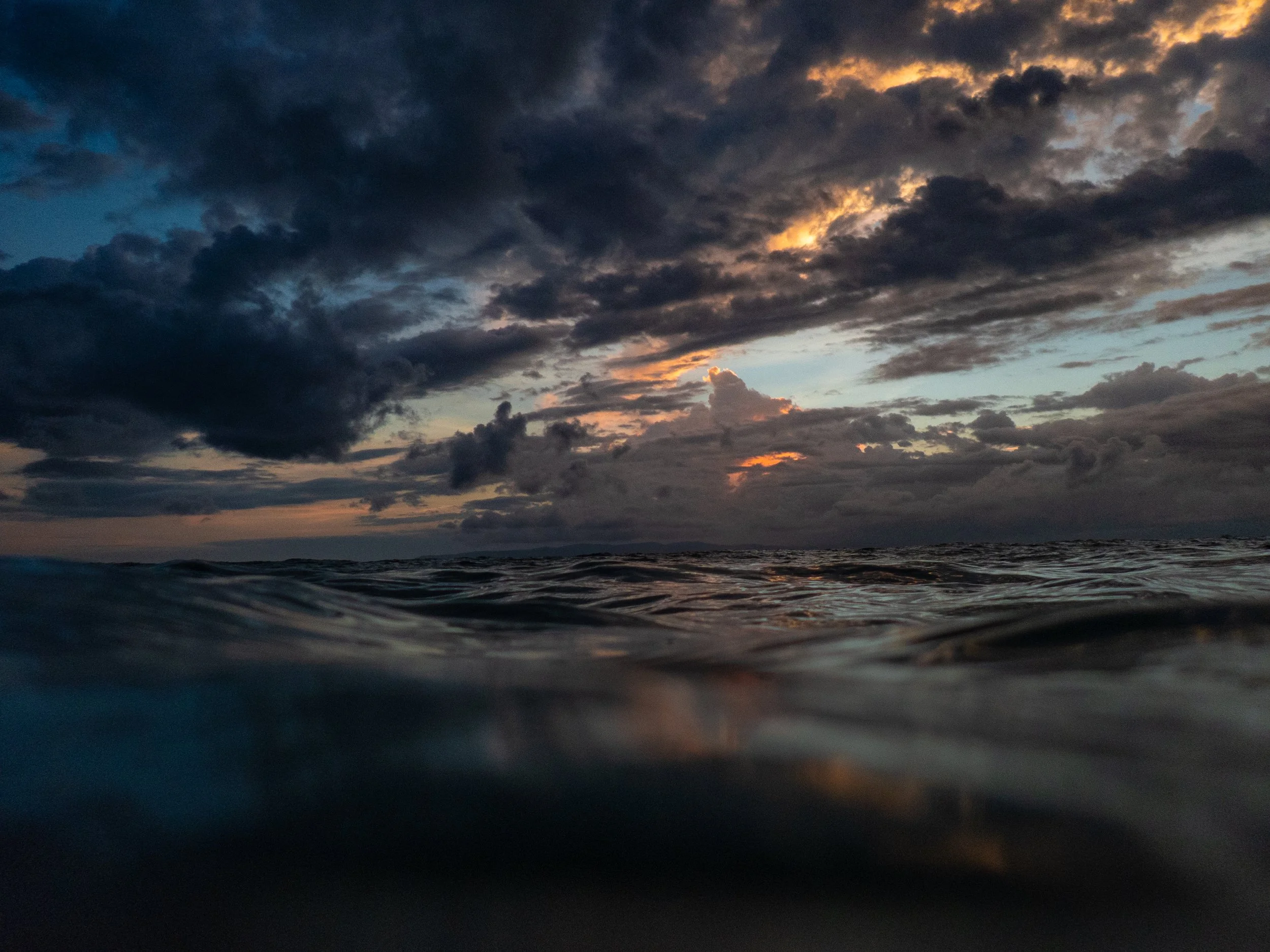 Cloudy sky over a body of water during sunset or twilight.