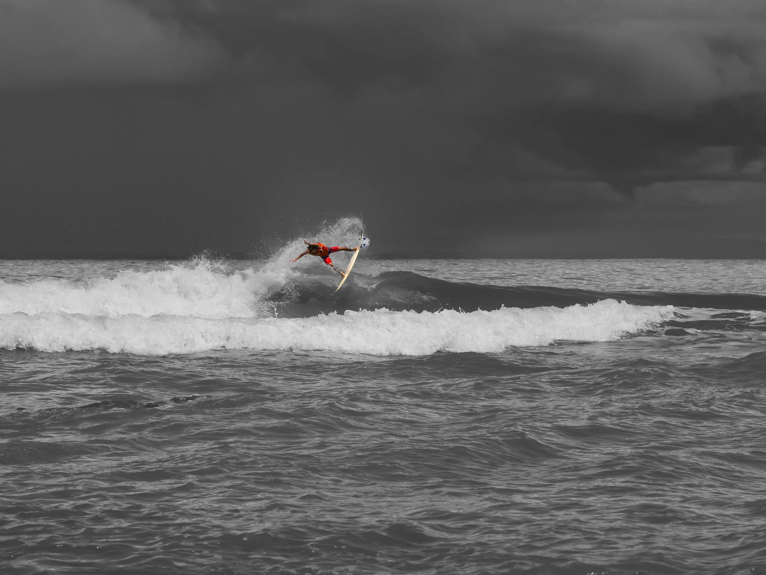 Surfer in red shorts performing trick on wave