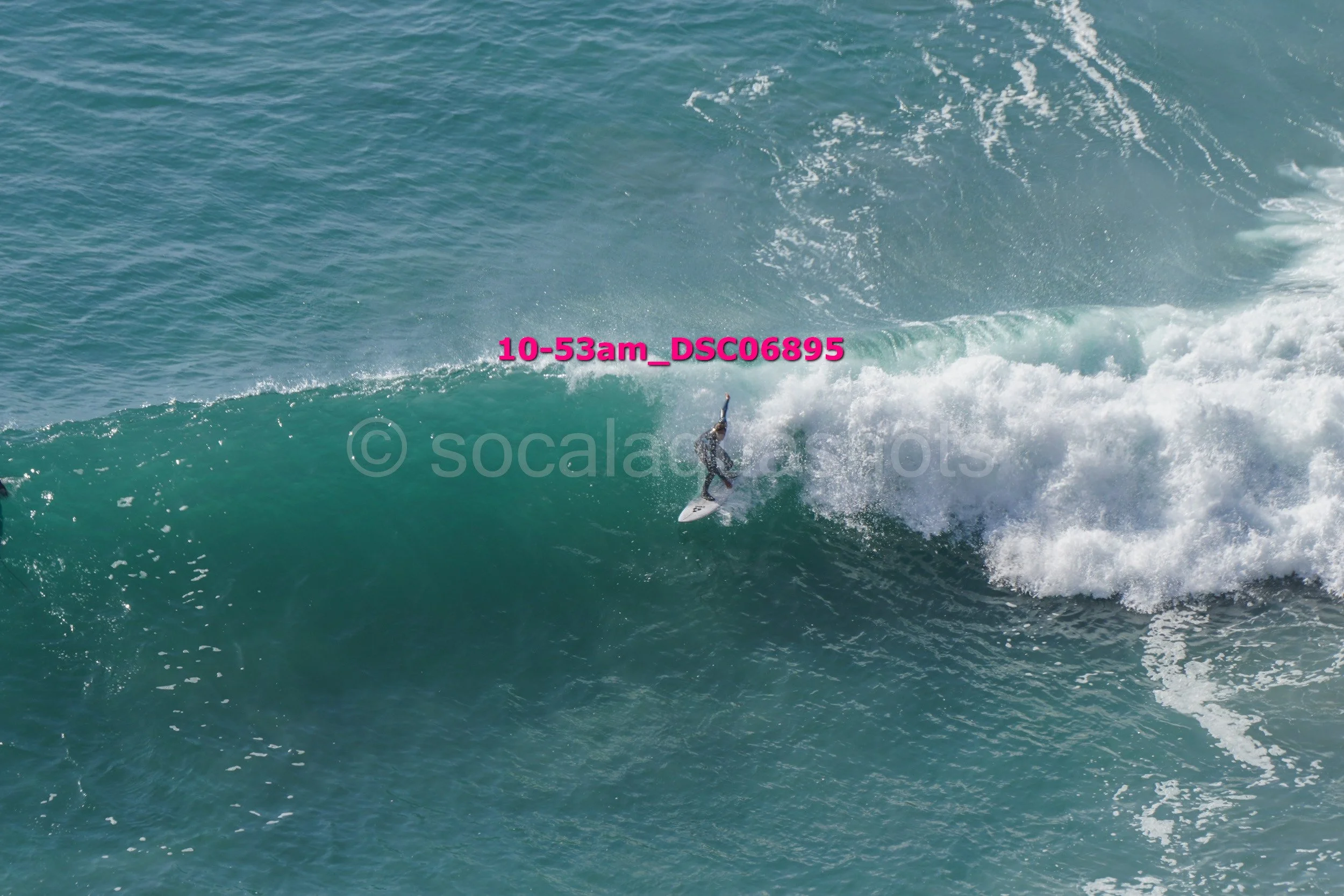 A person surfing on a large wave in the ocean.