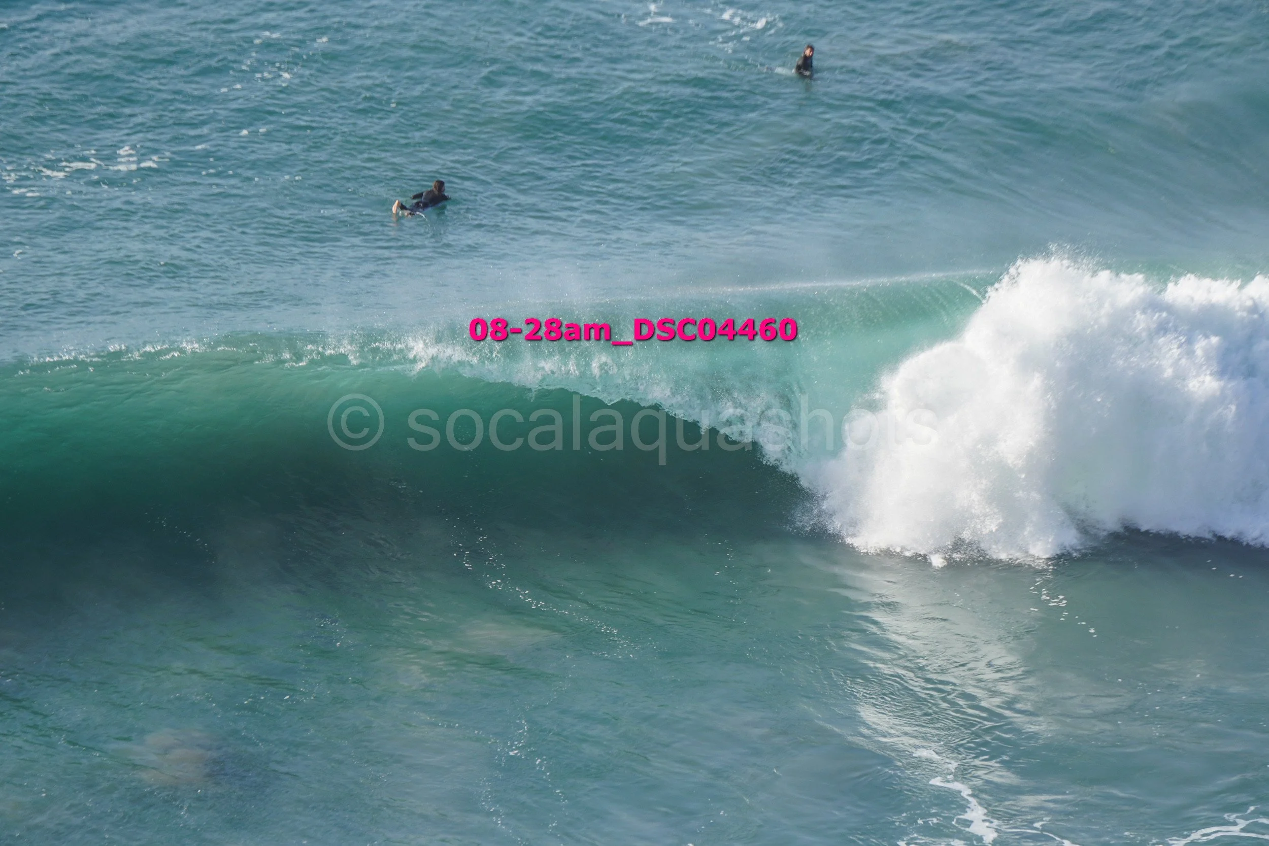 People surfing on a large ocean wave