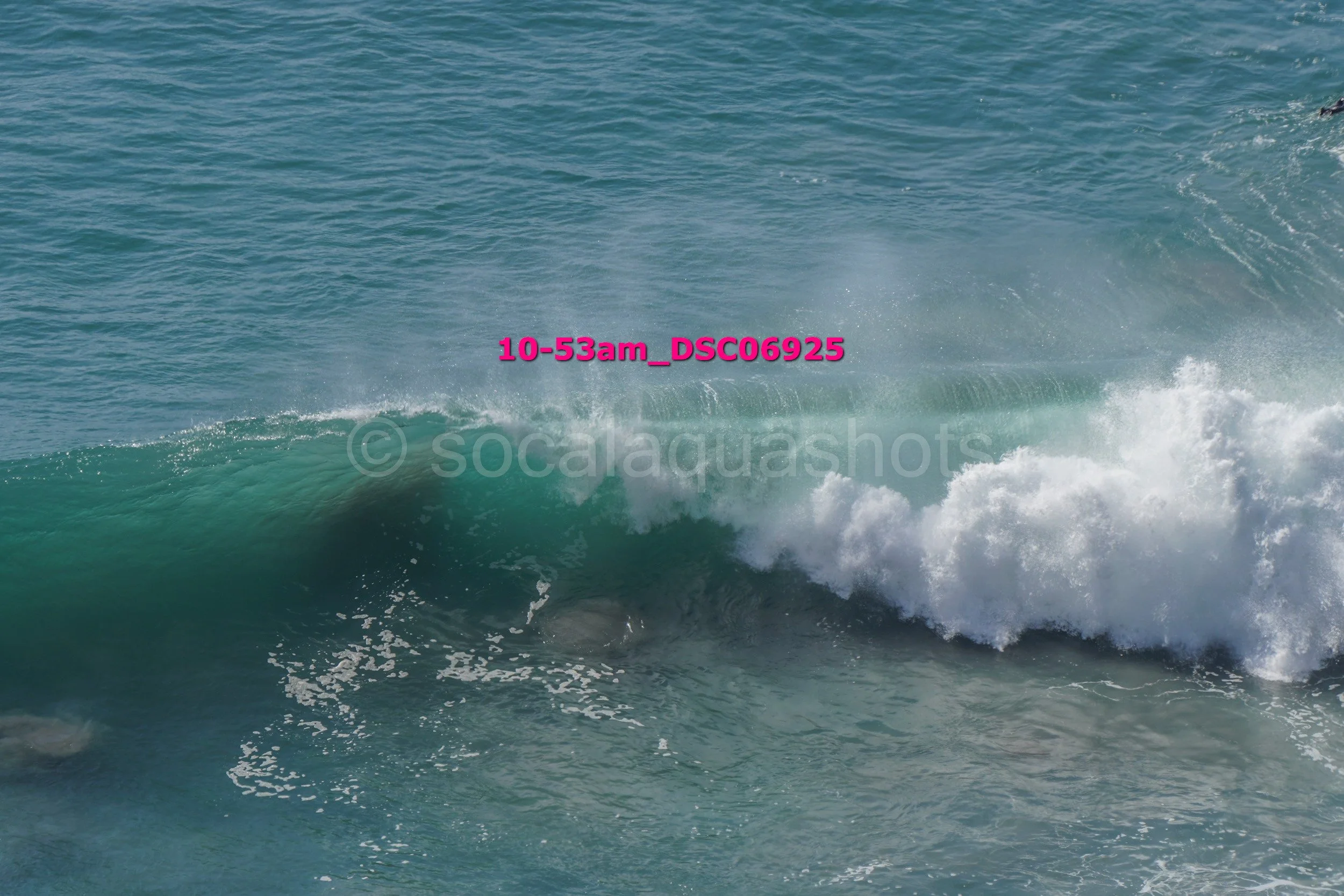 Ocean waves breaking with turquoise water, white foam, and spray.